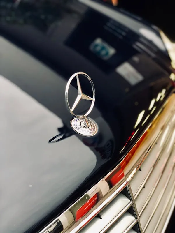 Mercedes Star Badge on Hood of Vintage Model Car Wallpaper