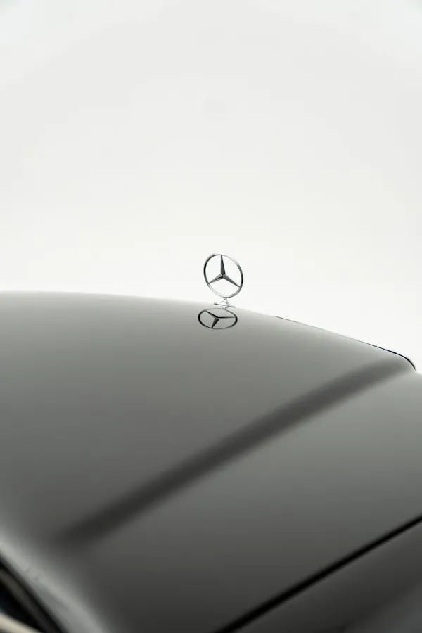 Mercedes Star Ornament on Black Car with White Backdrop