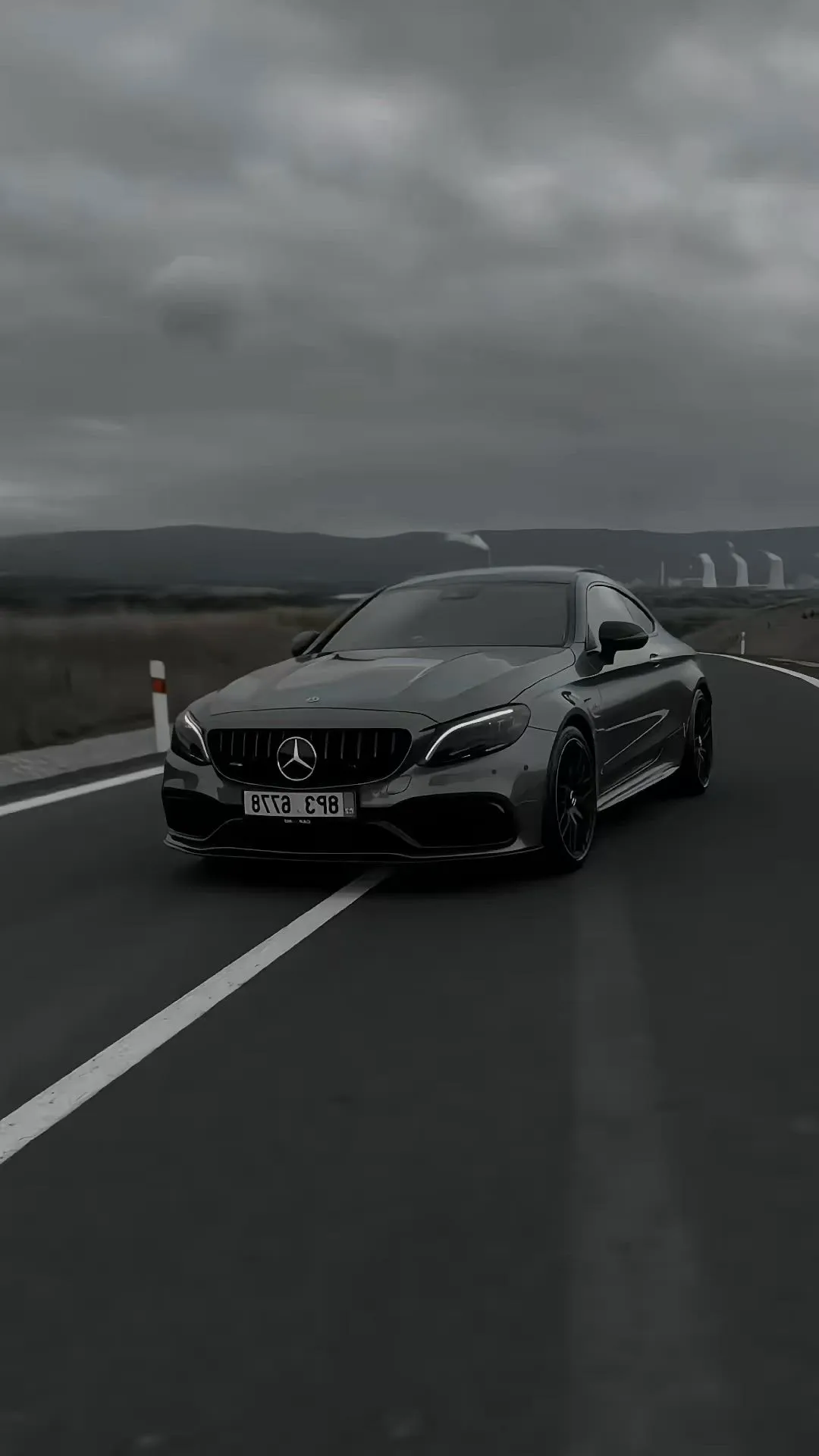 Modern Mercedes sports car driving on dark moody highway