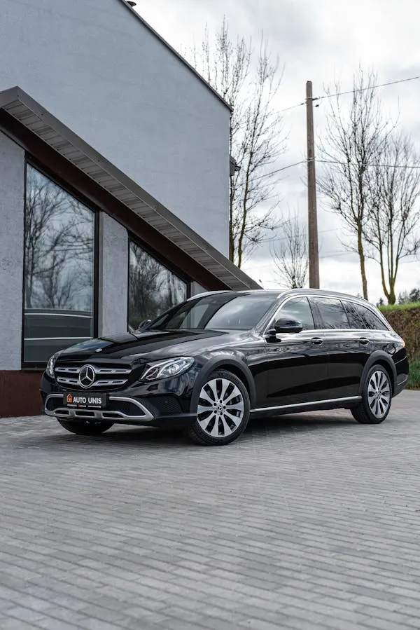 Modern Mercedes SUV in clean driveway near white wall