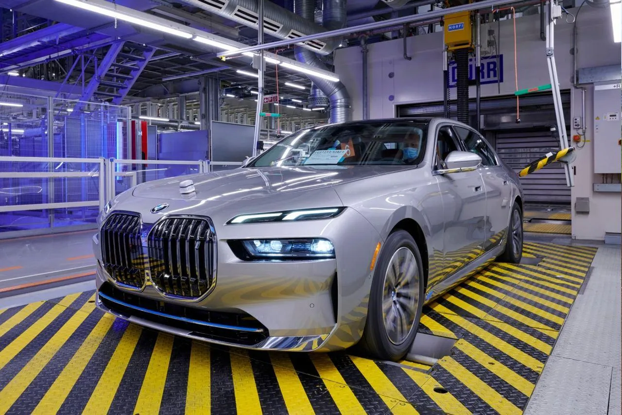 New Bmw Car Parked in Modern Industrial Facility Wallpaper
