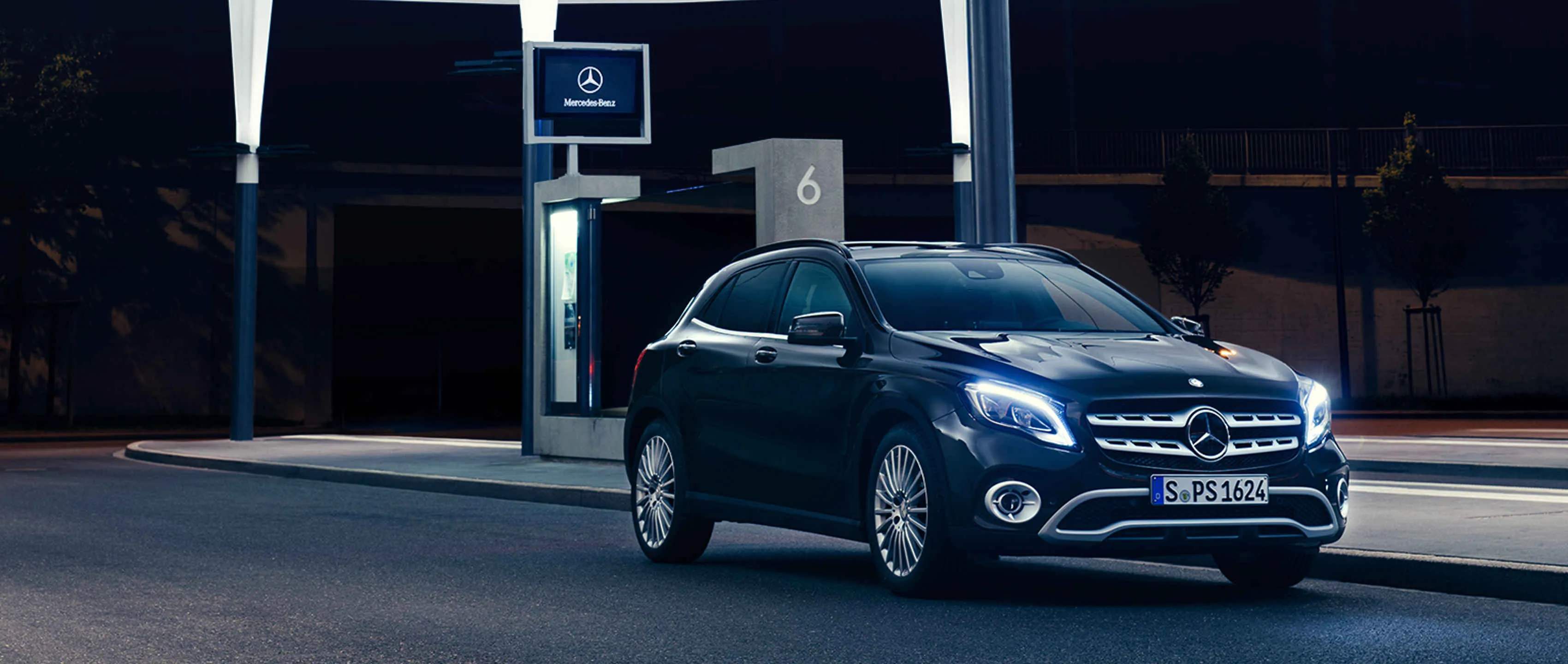 Night view of blue Mercedes Benz compact car at gas station
