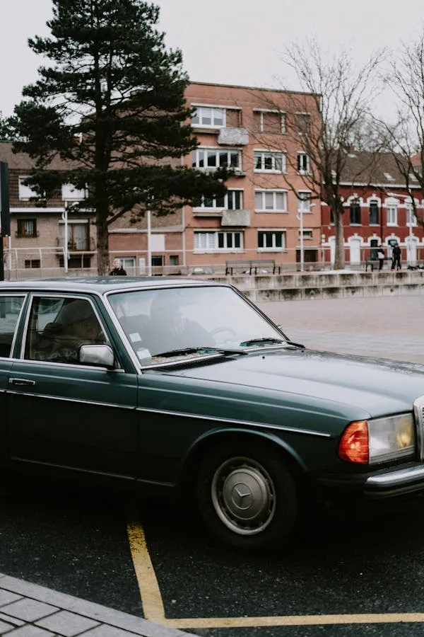 Old Mercedes parked near school in cold suburban street