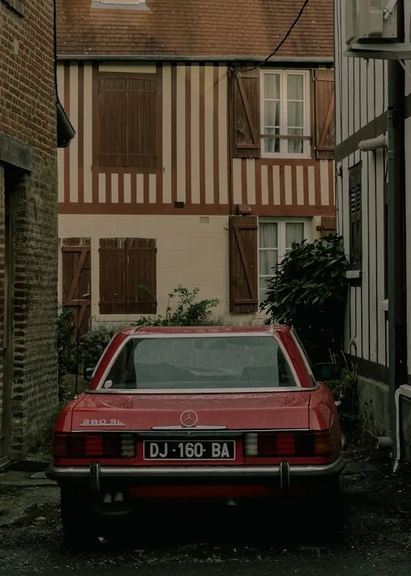 Old Red Mercedes Benz Parked Behind Classic House image