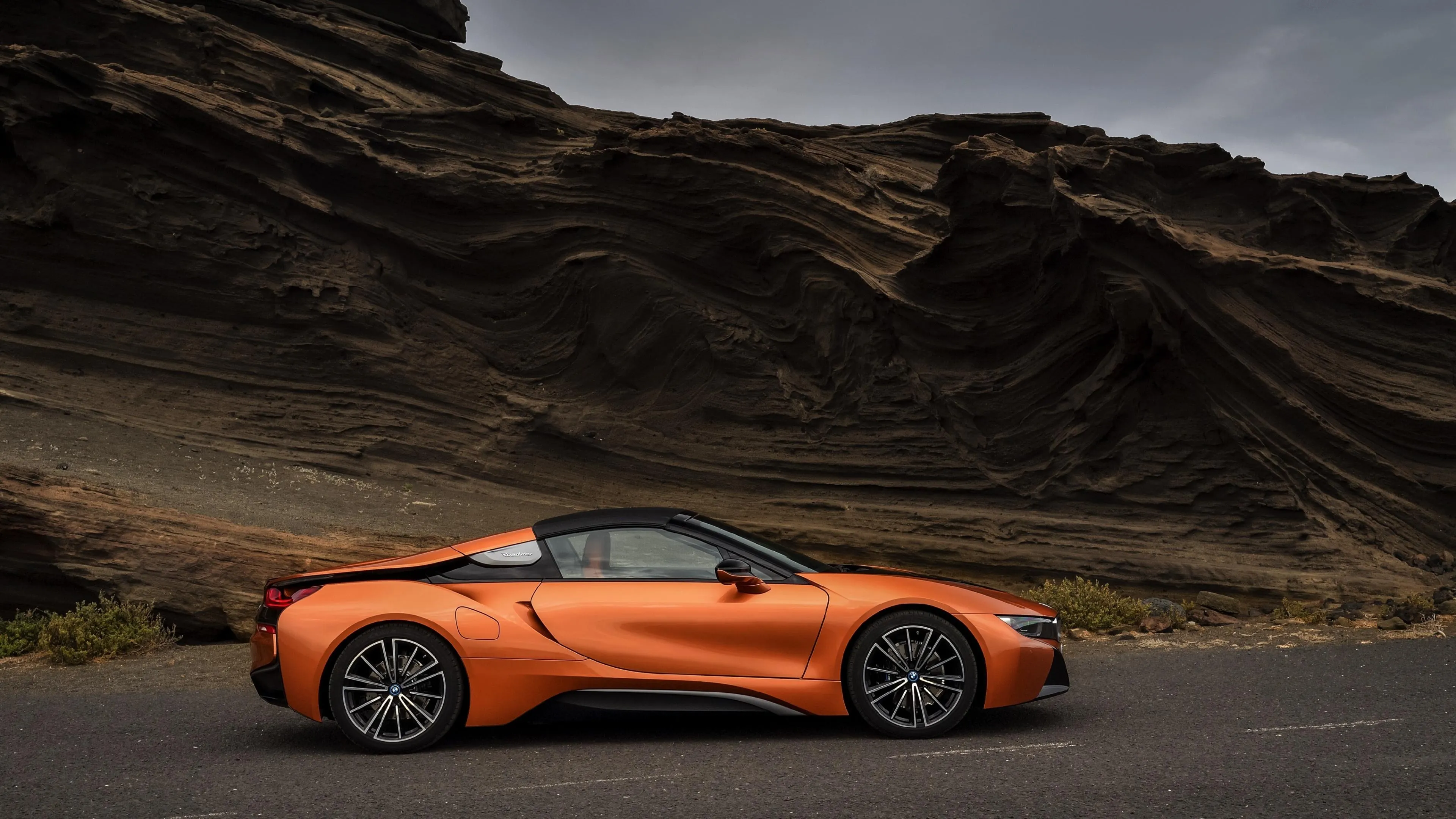 Orange Bmw Convertible Parked Near Dramatic Desert Hills