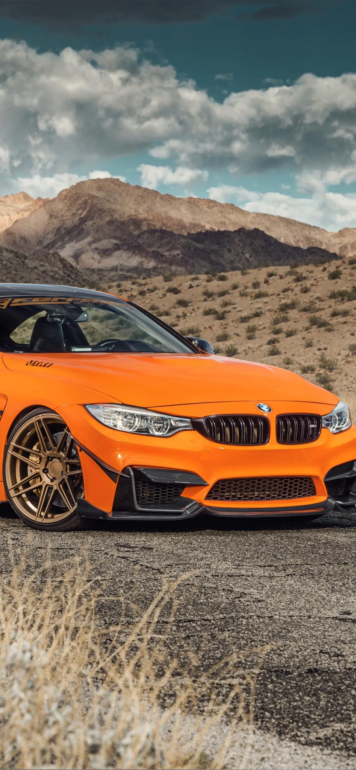 Orange Bmw Convertible Parked on Rocky Roadside Wallpaper
