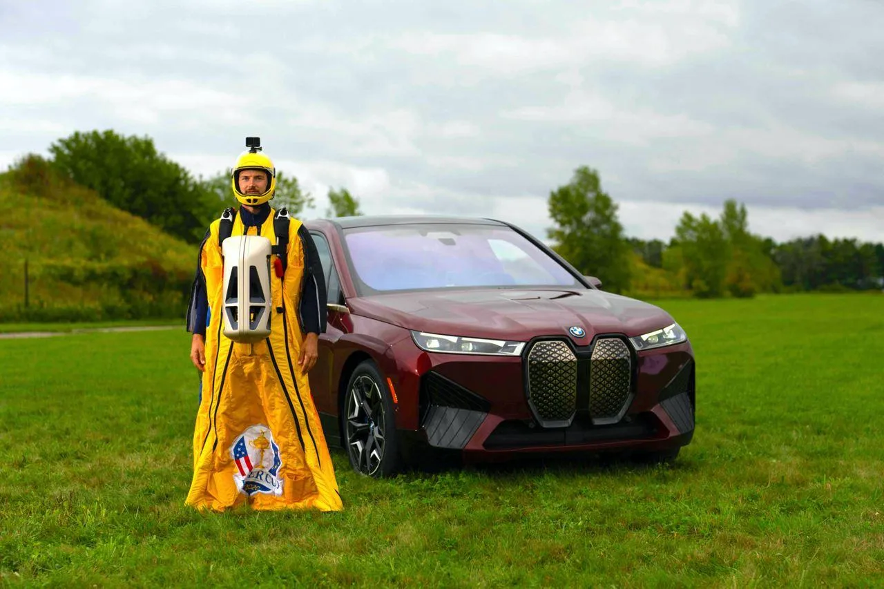 Person Standing Next To Bmw Car in Green Outdoor Setting