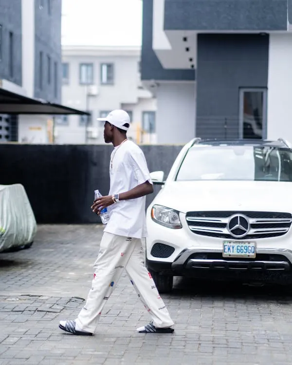 Person Walking Past a White Mercedes Benz Sedan Wallpaper