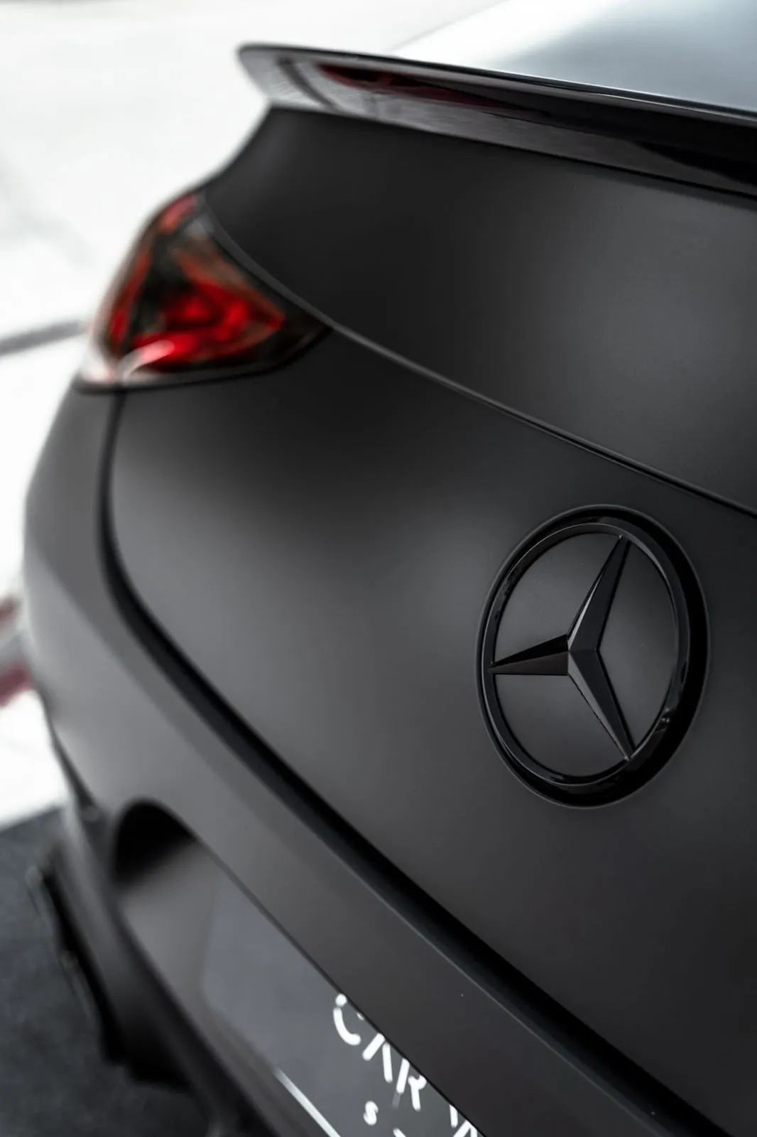 Rear close up of matte black Mercedes with logo focus