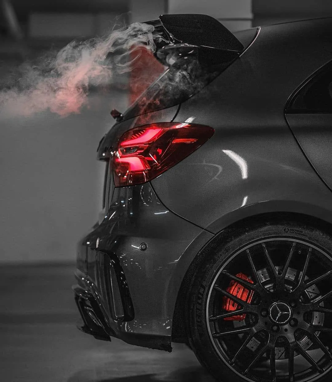 Rear Side View of Sporty Black Mercedes With Smoke