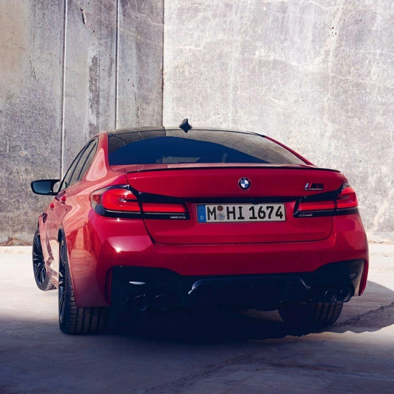 Rear View of a Red Bmw Parked in a Stone Paved Lane