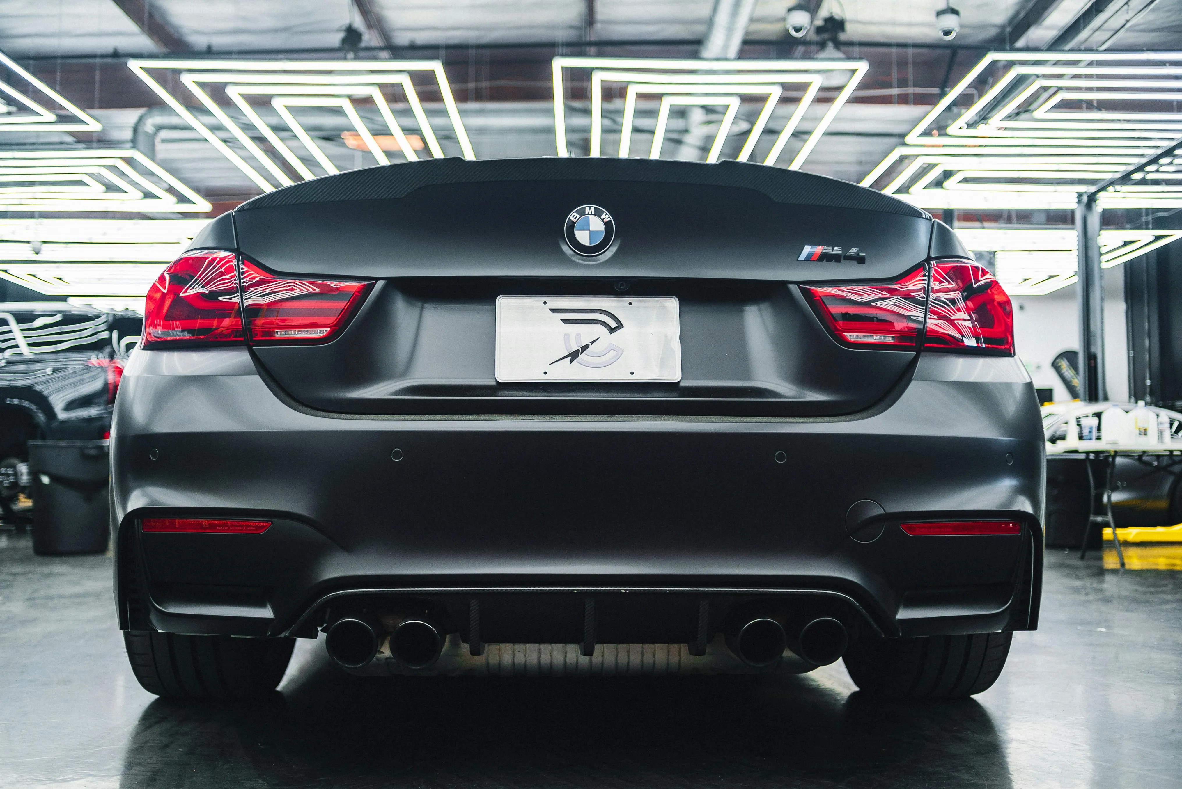 Rear View of Black Bmw Parked Inside Modern Showroom
