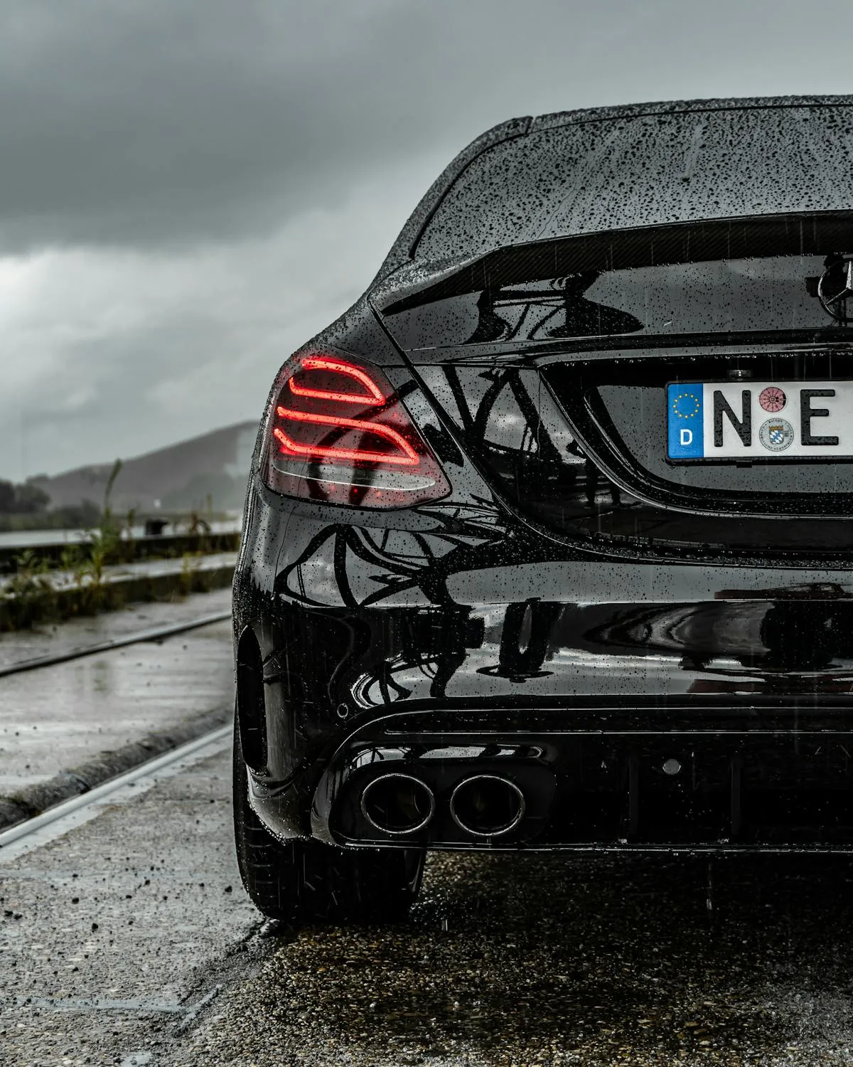 Rear View of Black Mercedes Benz on Wet Road Wallpaper