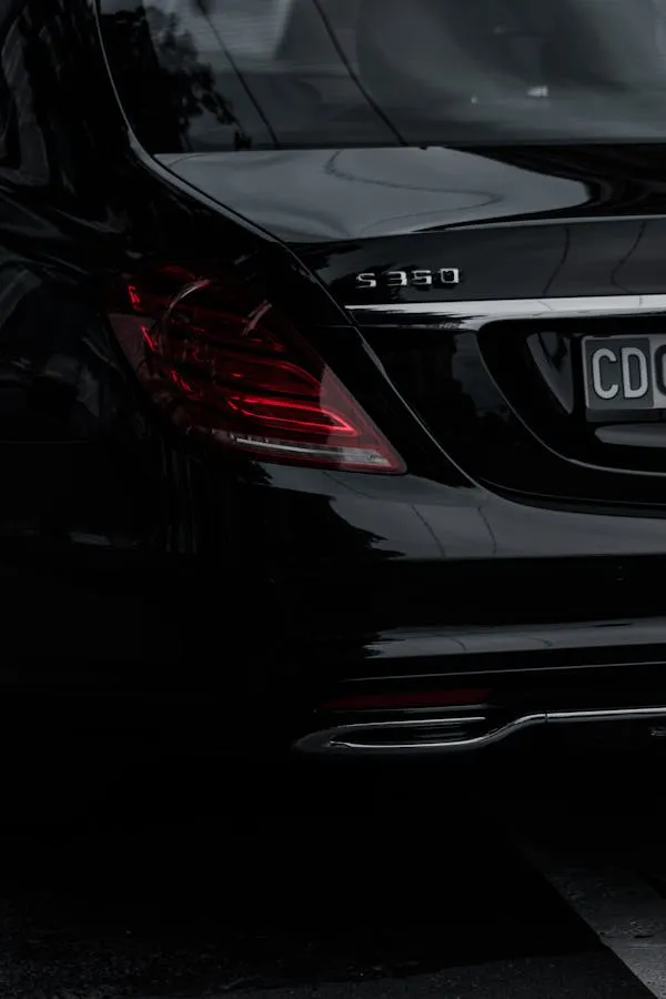 Rear View of Black Mercedes Benz Sedan with Tail Lights On
