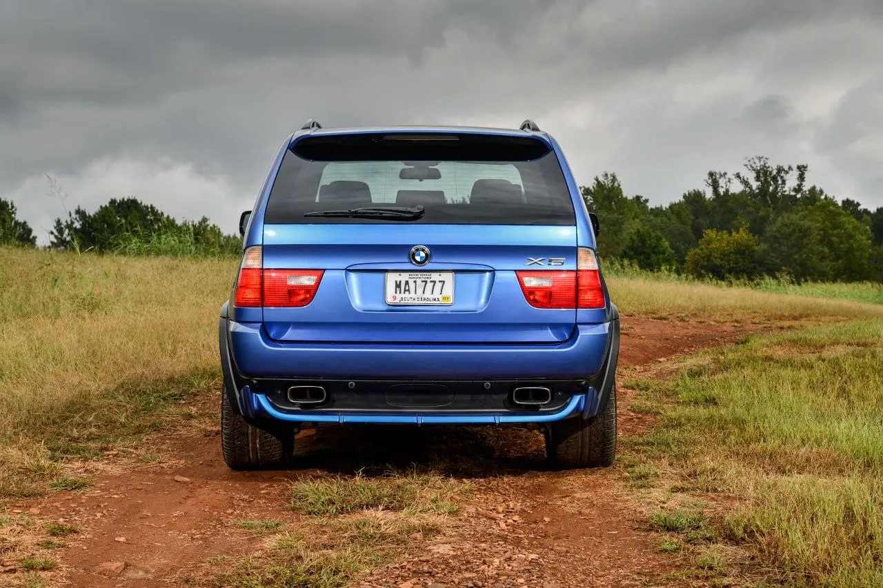Rear View of Blue Bmw Car on Dirt Road in Nature Wallpaper