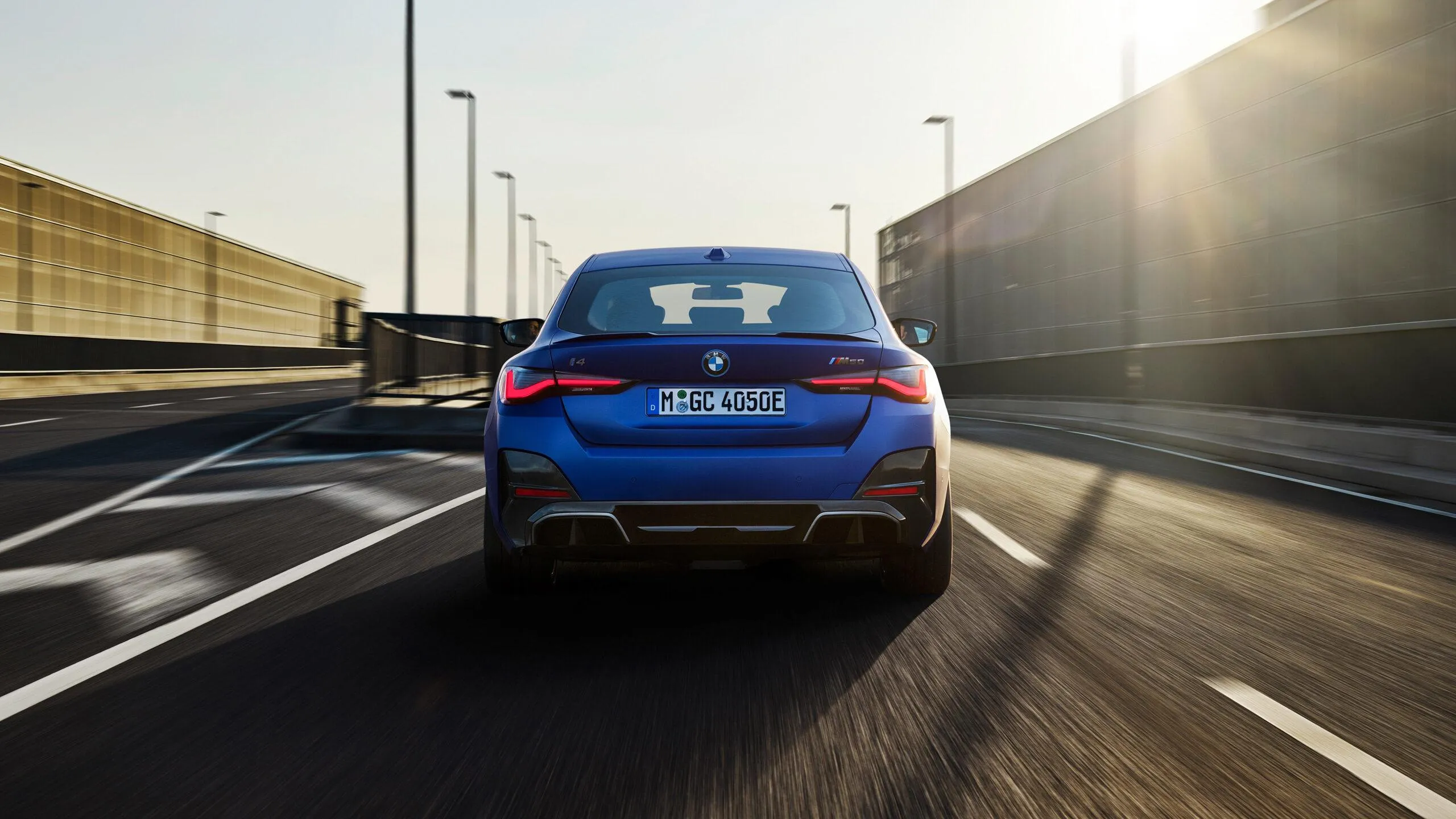 Rear View of Bmw Driving on Highway at Sunset Wallpaper