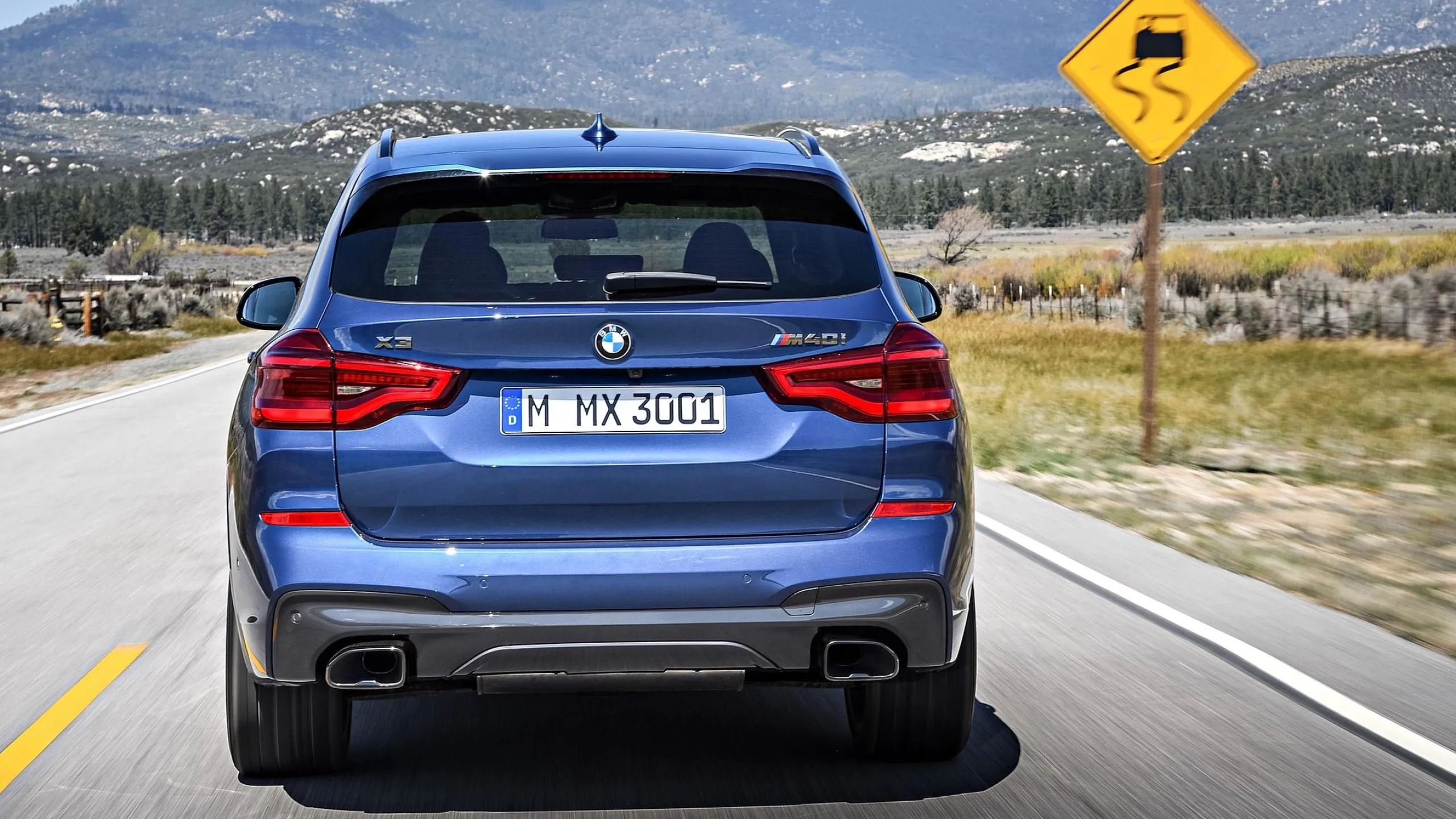 Rear View of Bmw Suv on Highway with Road Sign Ahead