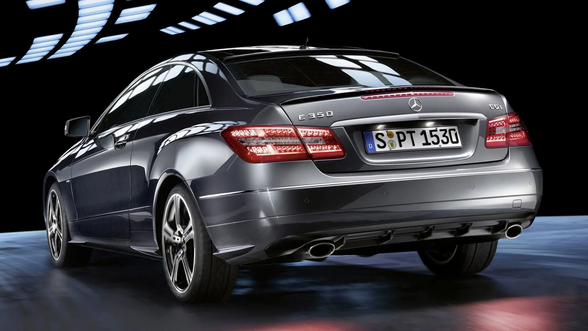 Rear View of Luxury Mercedes Under Display Lights Wallpaper