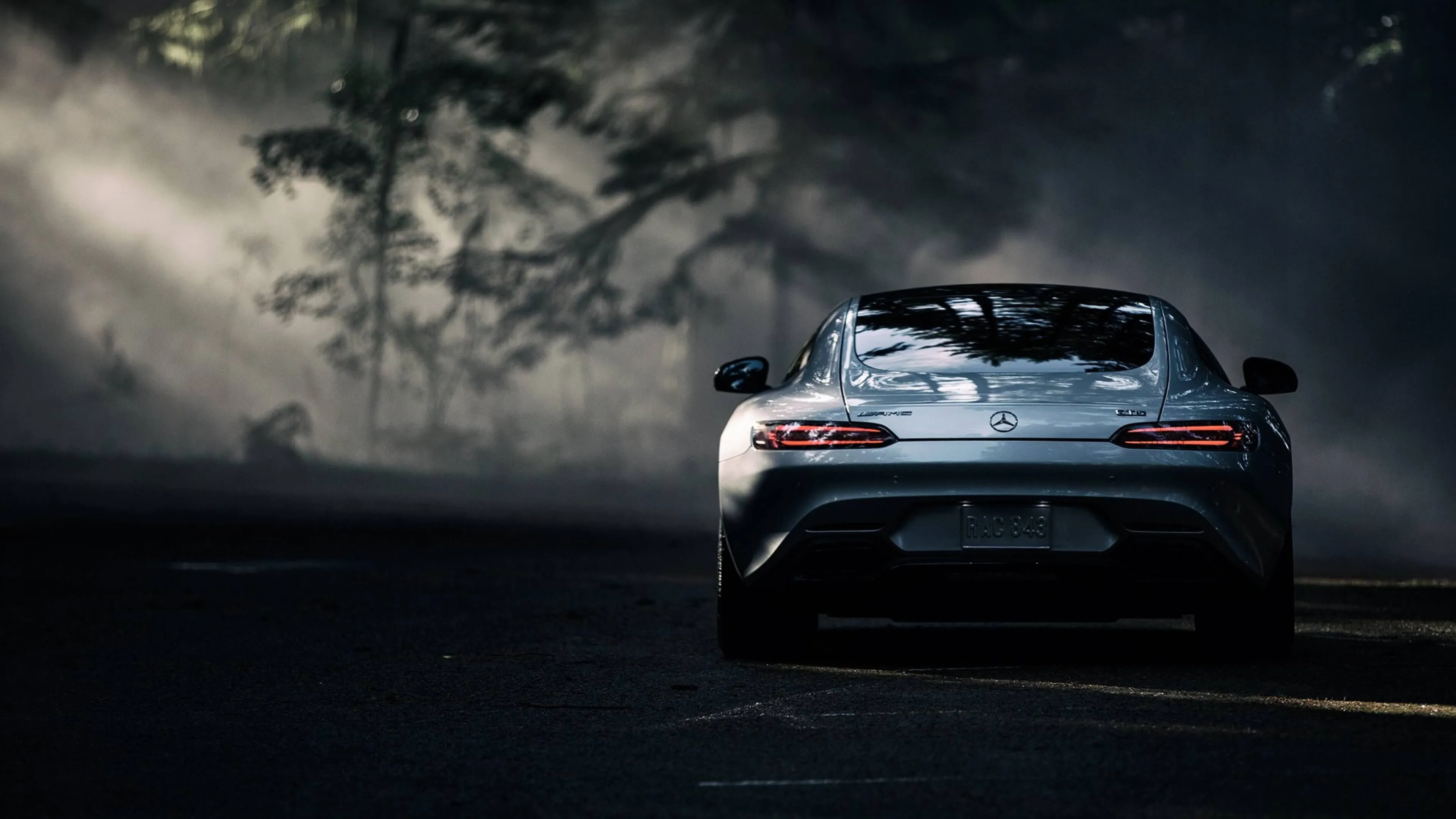 Rear View of Mercedes Supercar Driving on Foogy Road