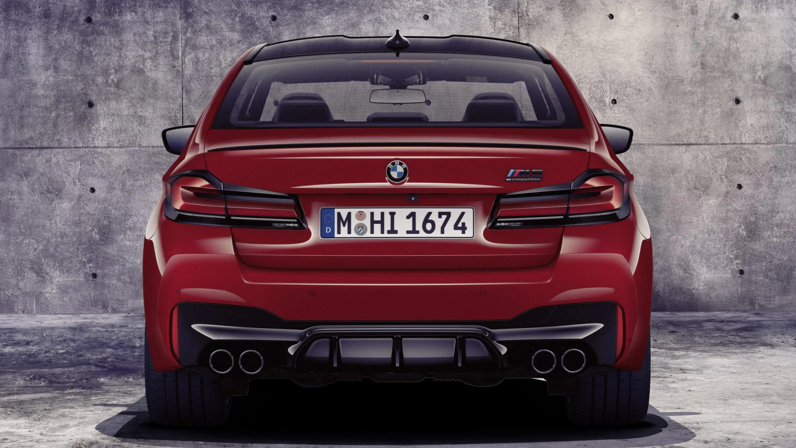 Rear View of Powerful Red Bmw Parked Near Concrete Wall
