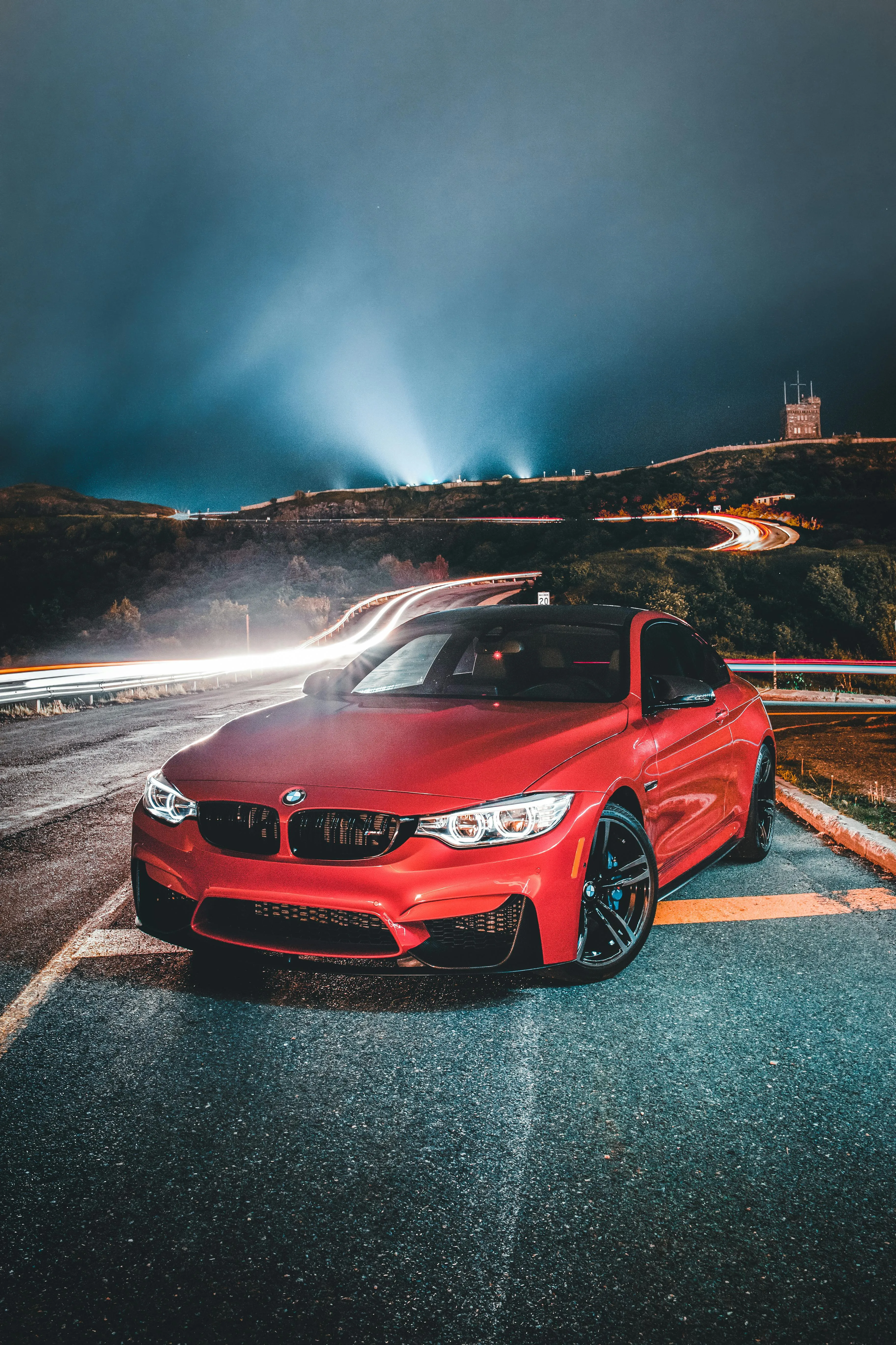 Red Bmw Captured on a Wet Night Road with Reflections