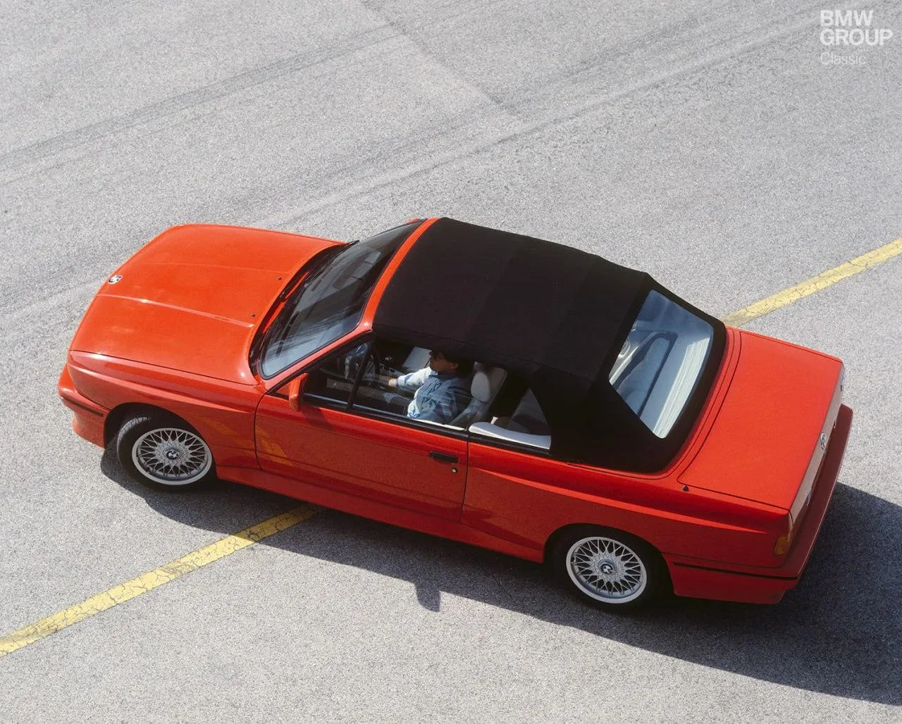 Red Bmw Convertible Driving on Urban Concrete Road