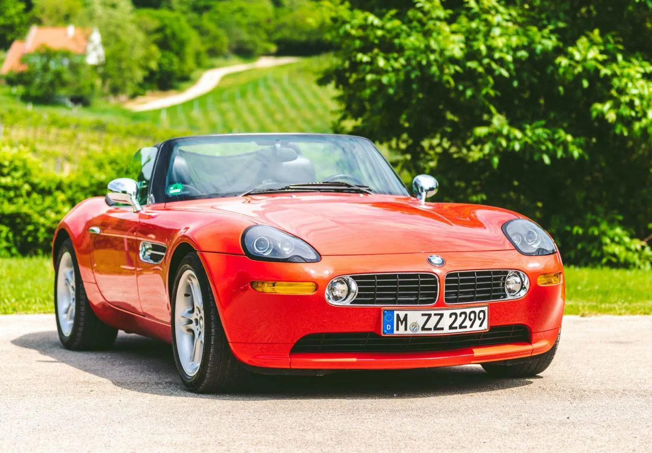 Red Bmw Convertible Parked in Sunlit Green Countryside