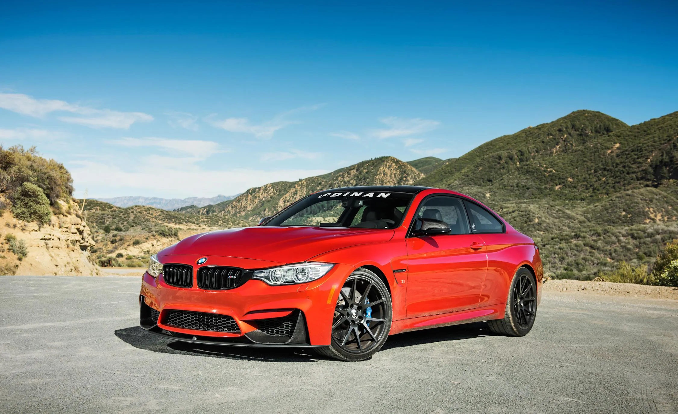 Red Bmw Coupe Parked on Sunny Road with Mountain Backdrop