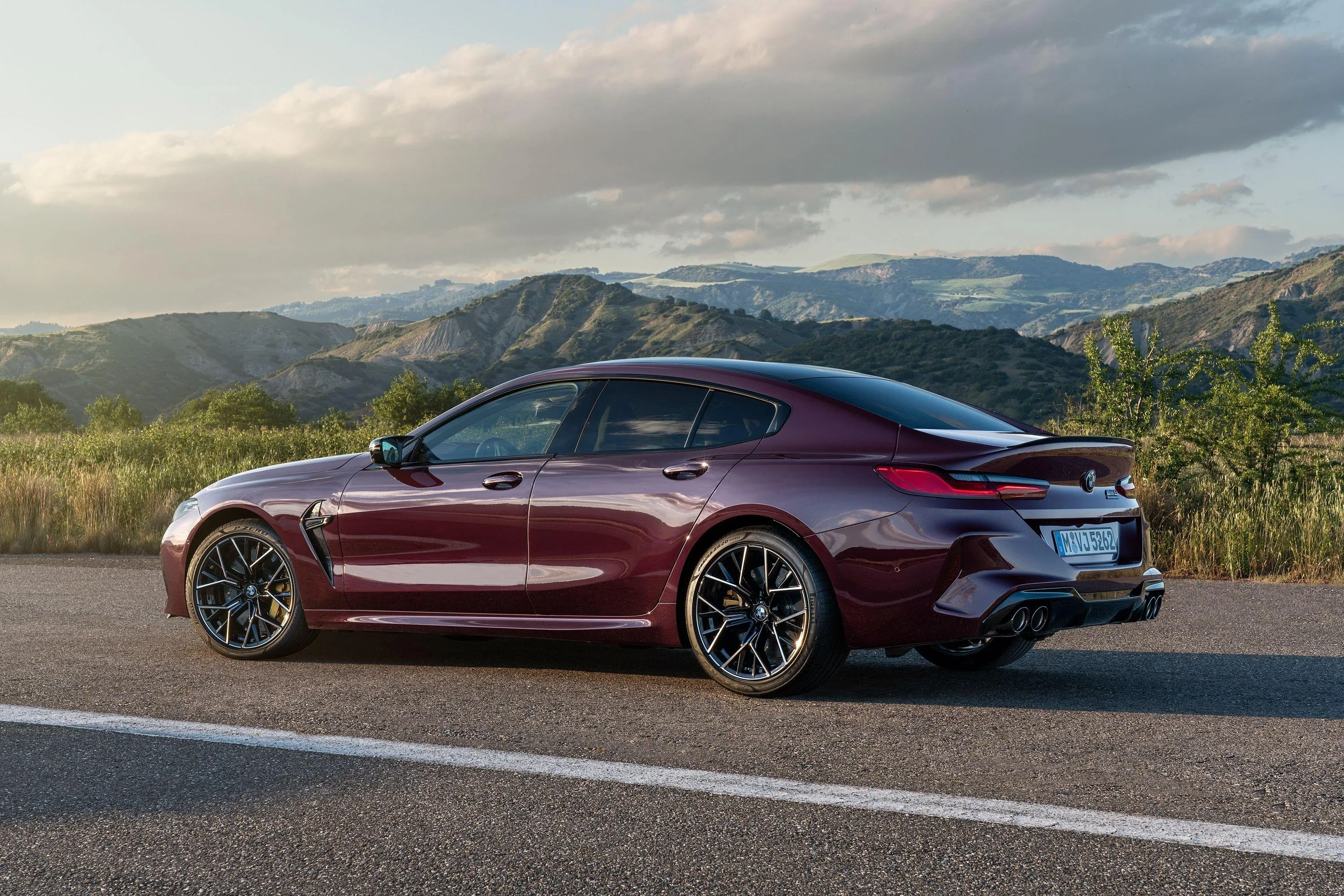 Red Bmw Coupe Parked with Scenic Mountains and Cloudy Sky