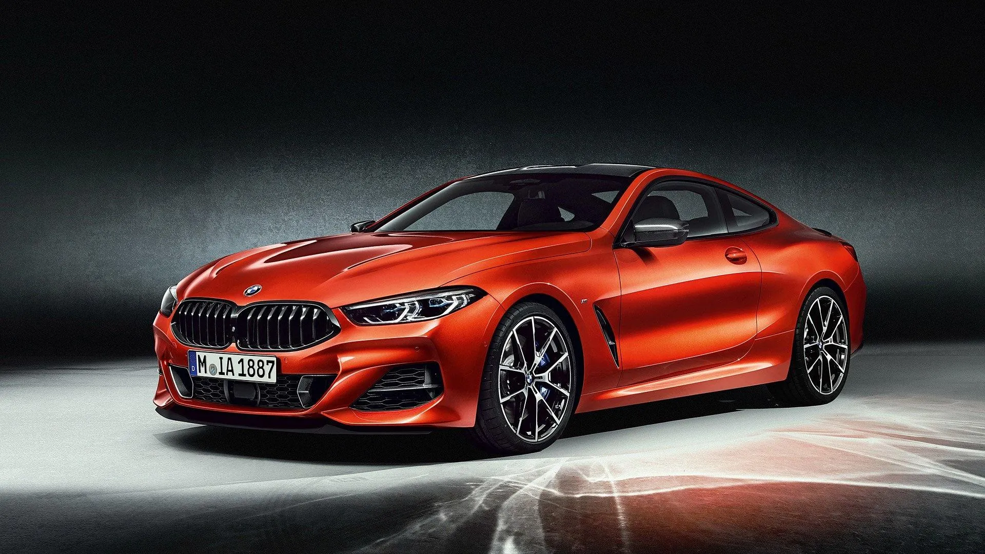 Red Bmw Coupe Under Spotlight in Dark Studio Environment