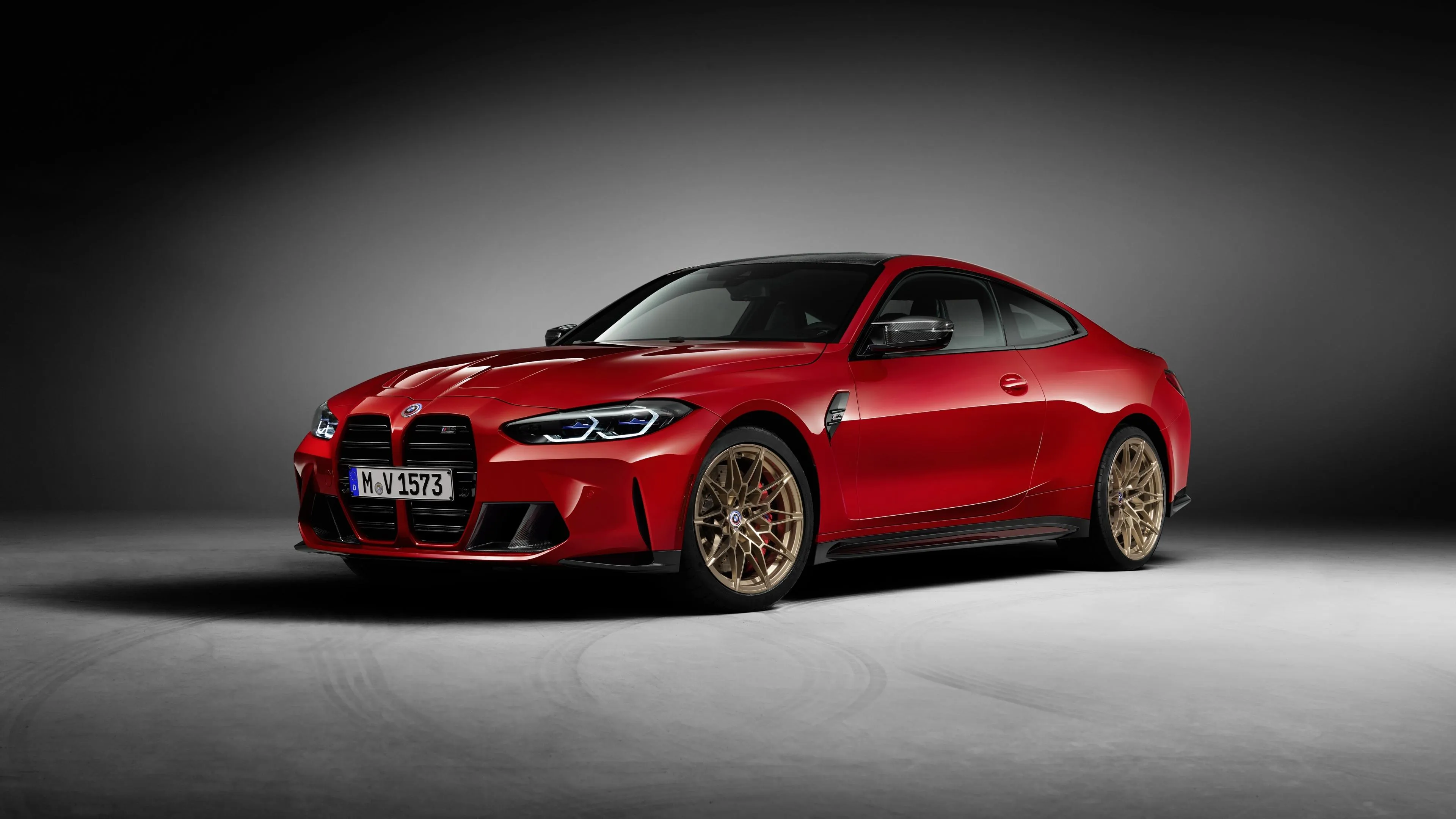 Red Bmw Coupe with Golden Wheels Highlighted in Studio Light