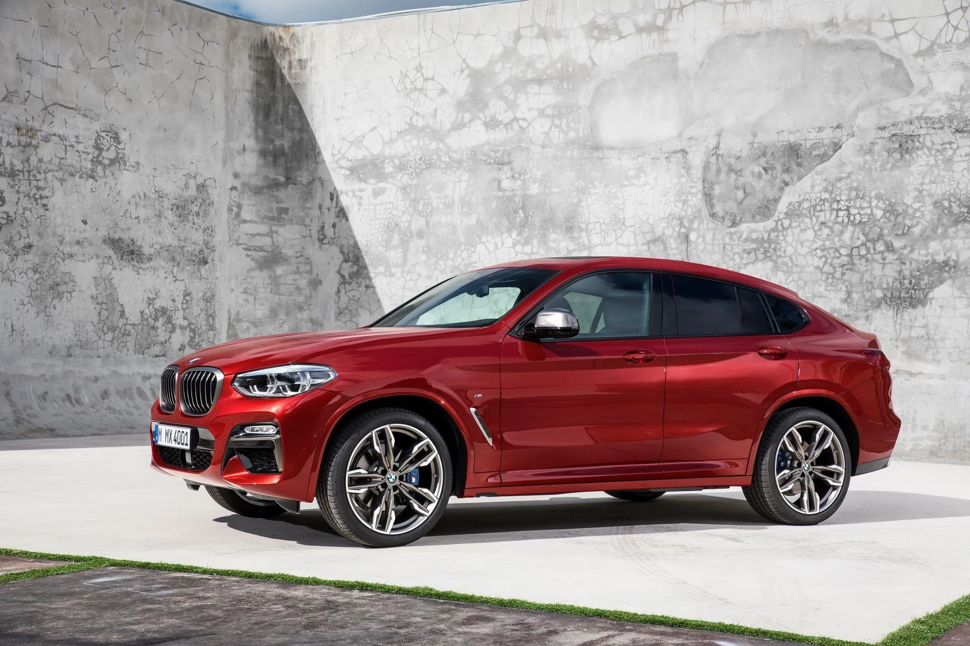 Red Bmw Crossover Displayed Indoors on White Platform