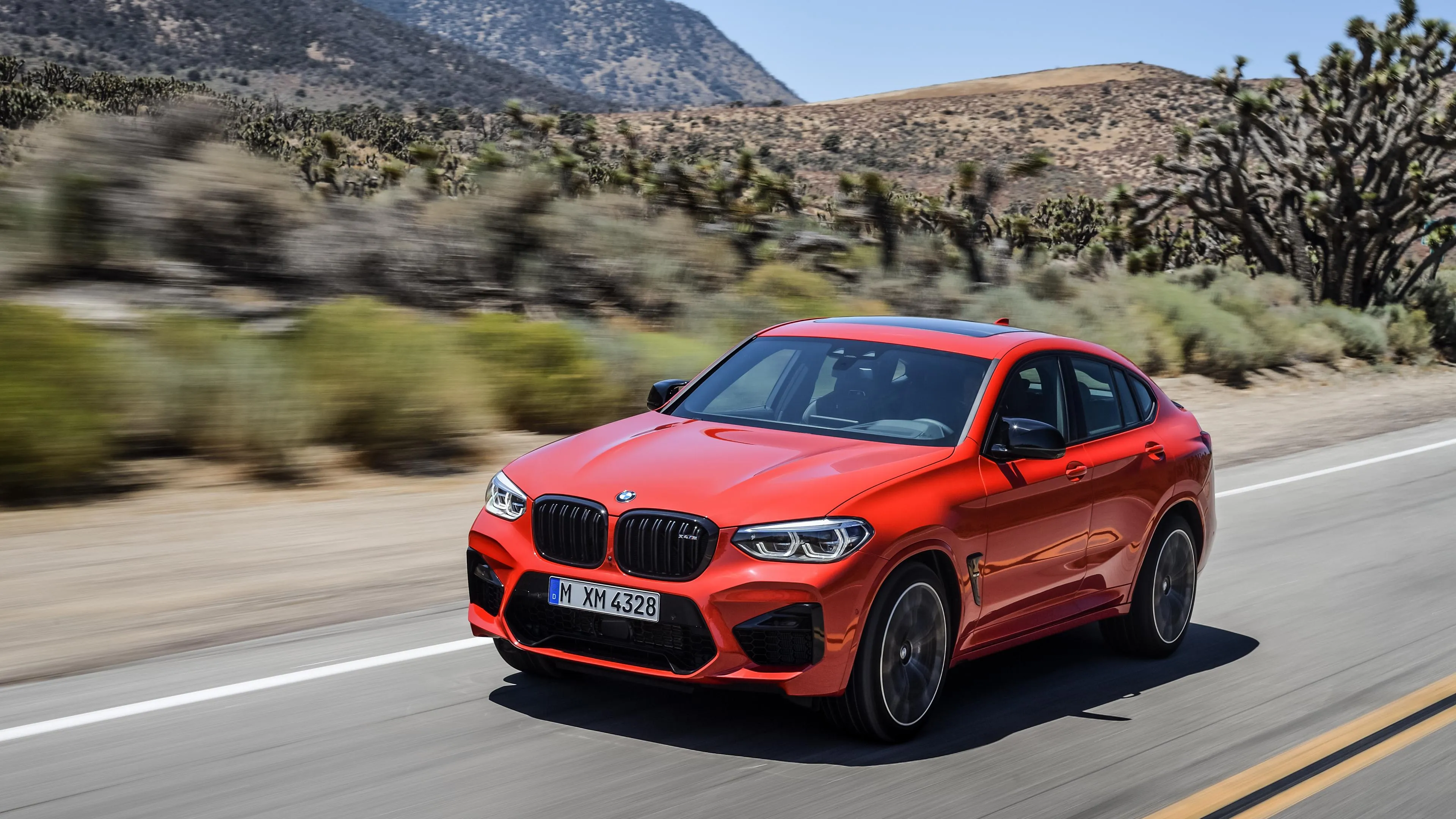 Red Bmw Crossover Driving Fast on Scenic Winding Road