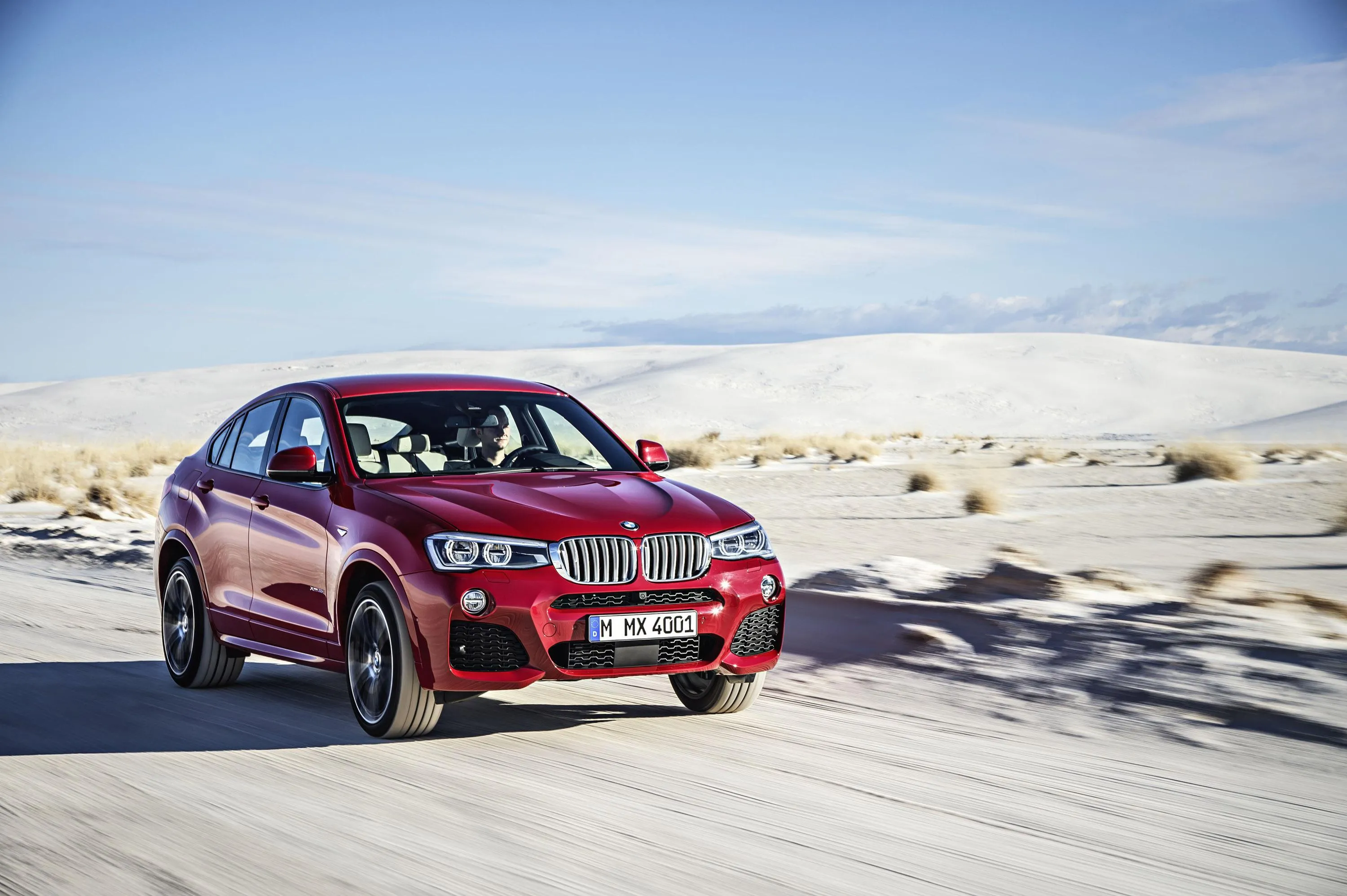 Red Bmw Driving Across Bright White Desert Landscape