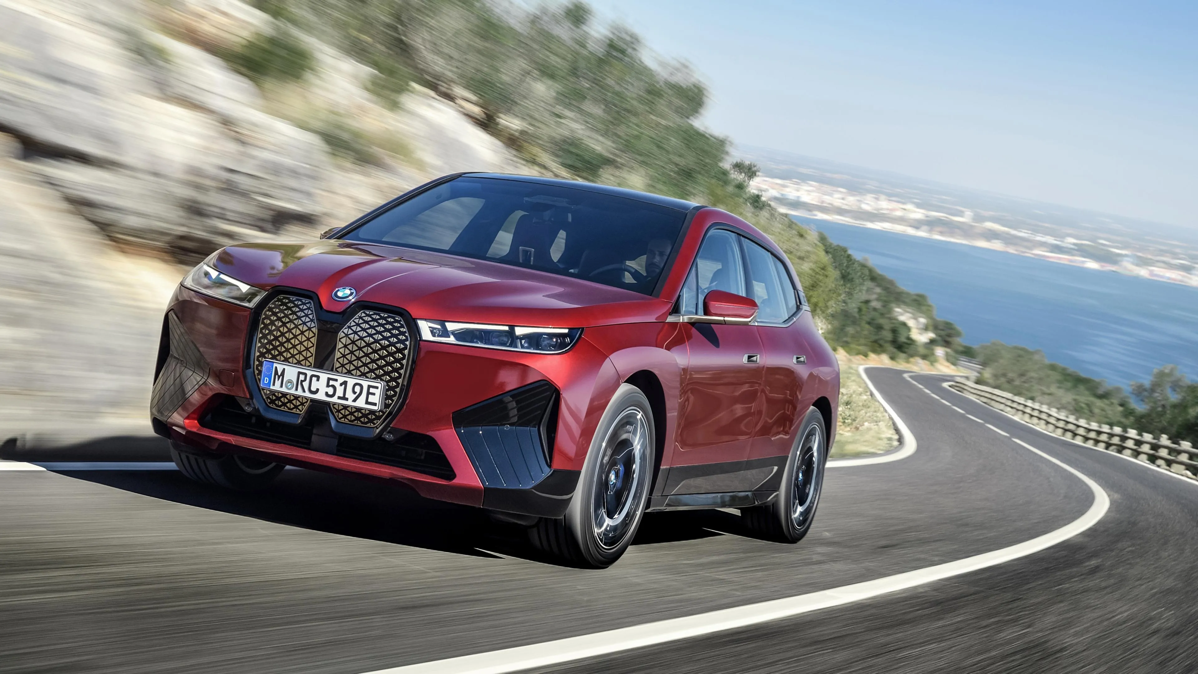 Red Bmw Driving Along Scenic Coastal Highway Curve