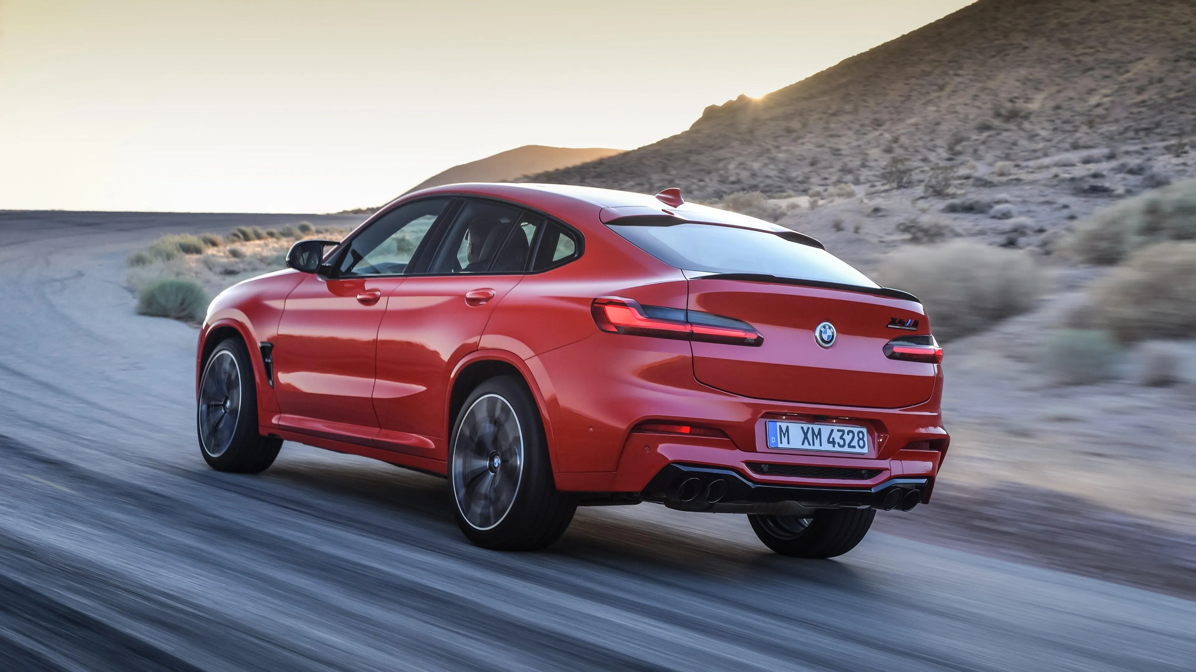Red Bmw Driving Fast on Desert Highway with Clear Sky Wallpaper