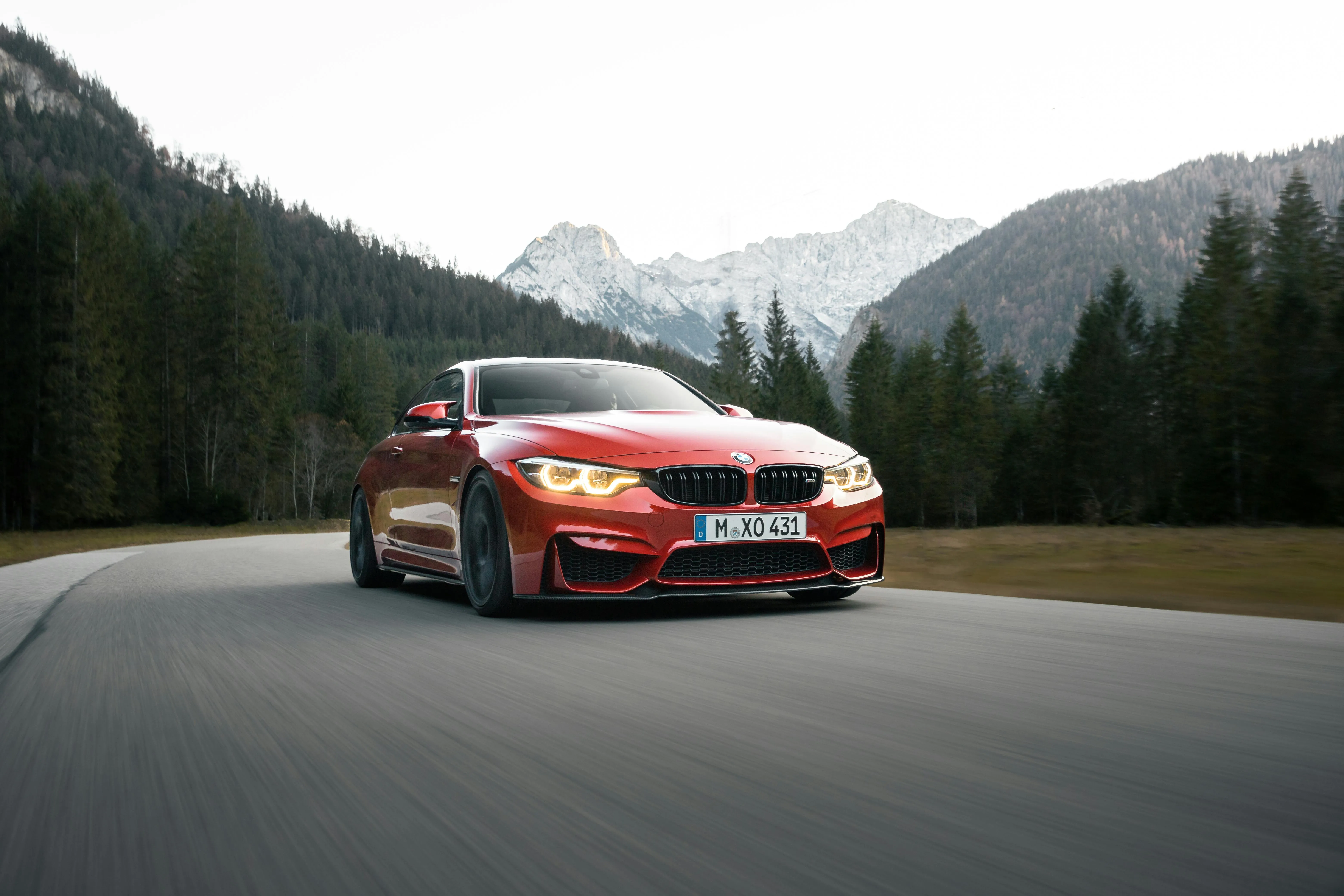 Red Bmw Driving on a Mountain Road Surrounded By Forest
