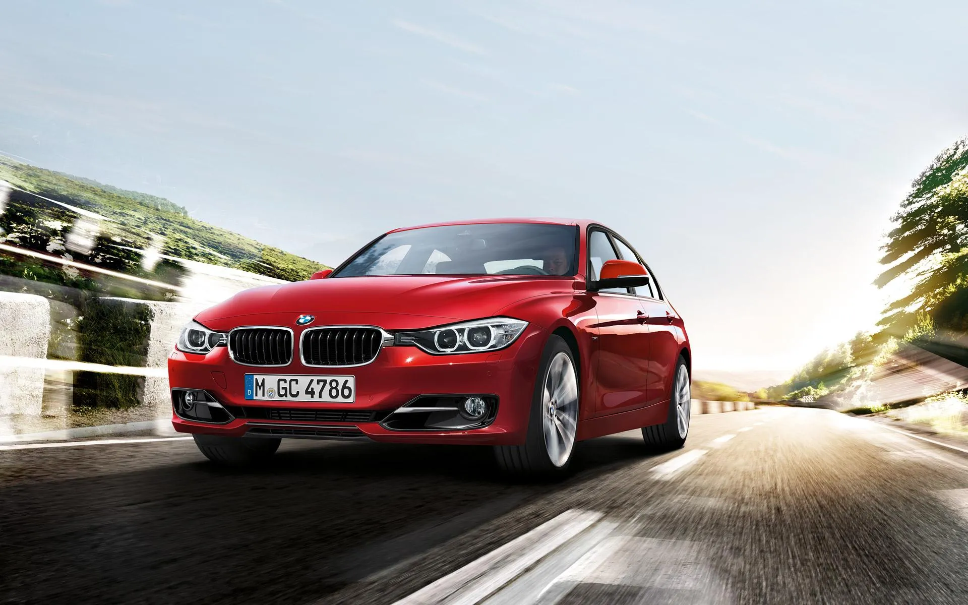 Red Bmw Driving on a Sunny Roadside with Trees Wallpaper