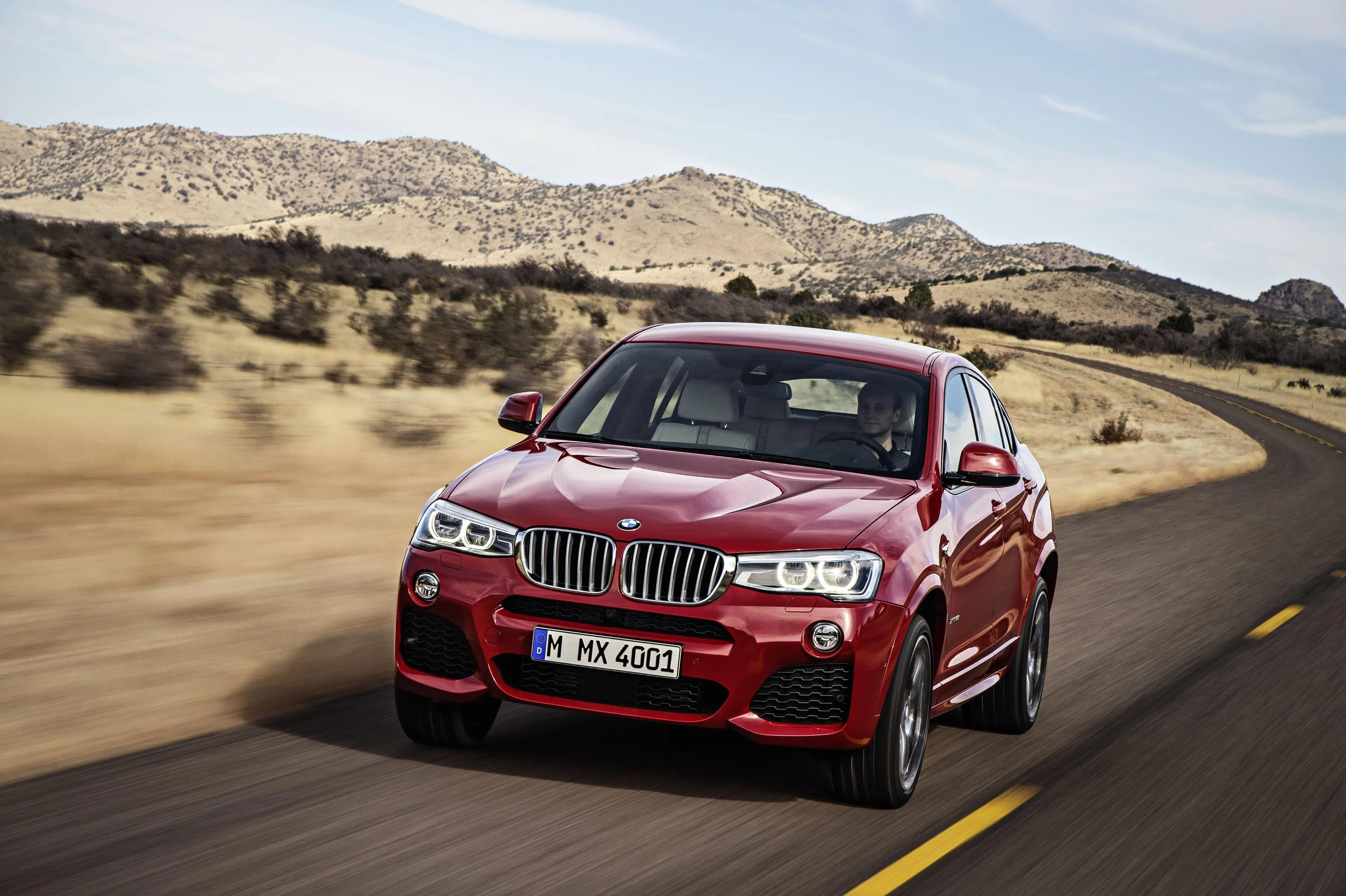 Red Bmw Driving Through Scenic Desert Highway Image