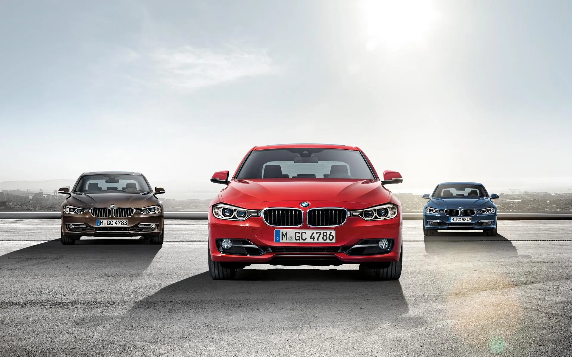 Red Bmw Leading a Line of Cars on Open Road Wallpaper