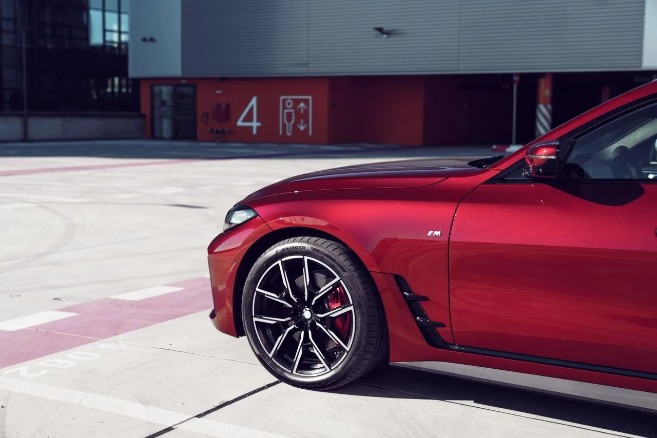 Red Bmw Parked Near an Airport Hangar on Sunny Day