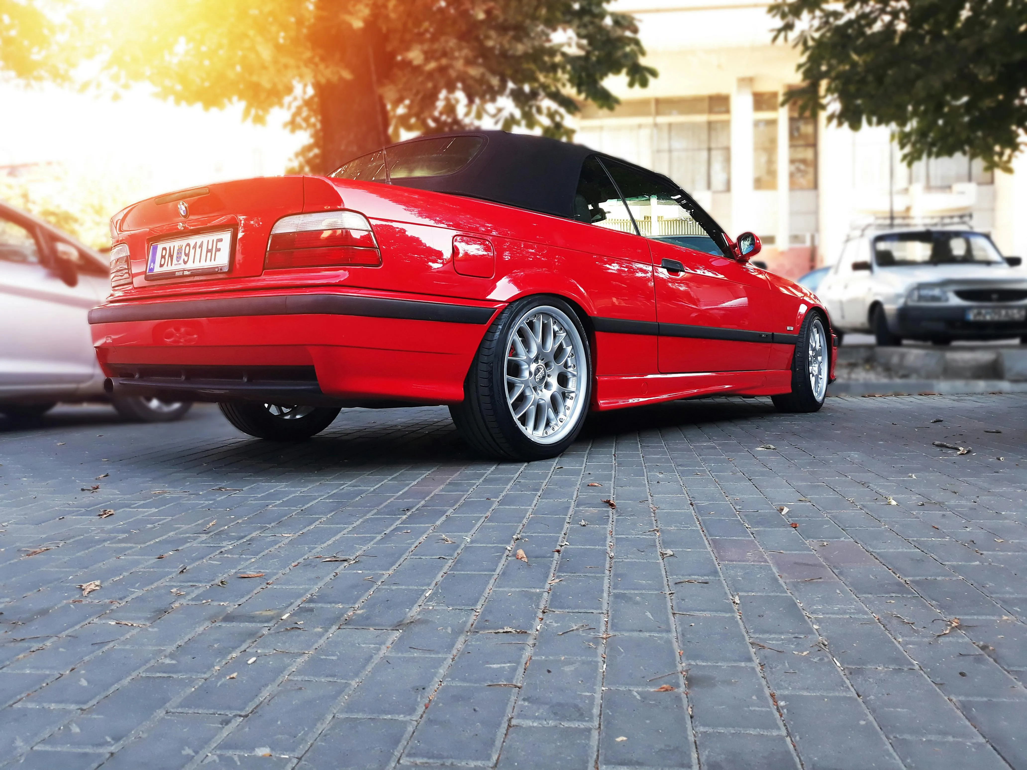 Red Bmw Parked on City Street with Golden Sunlight