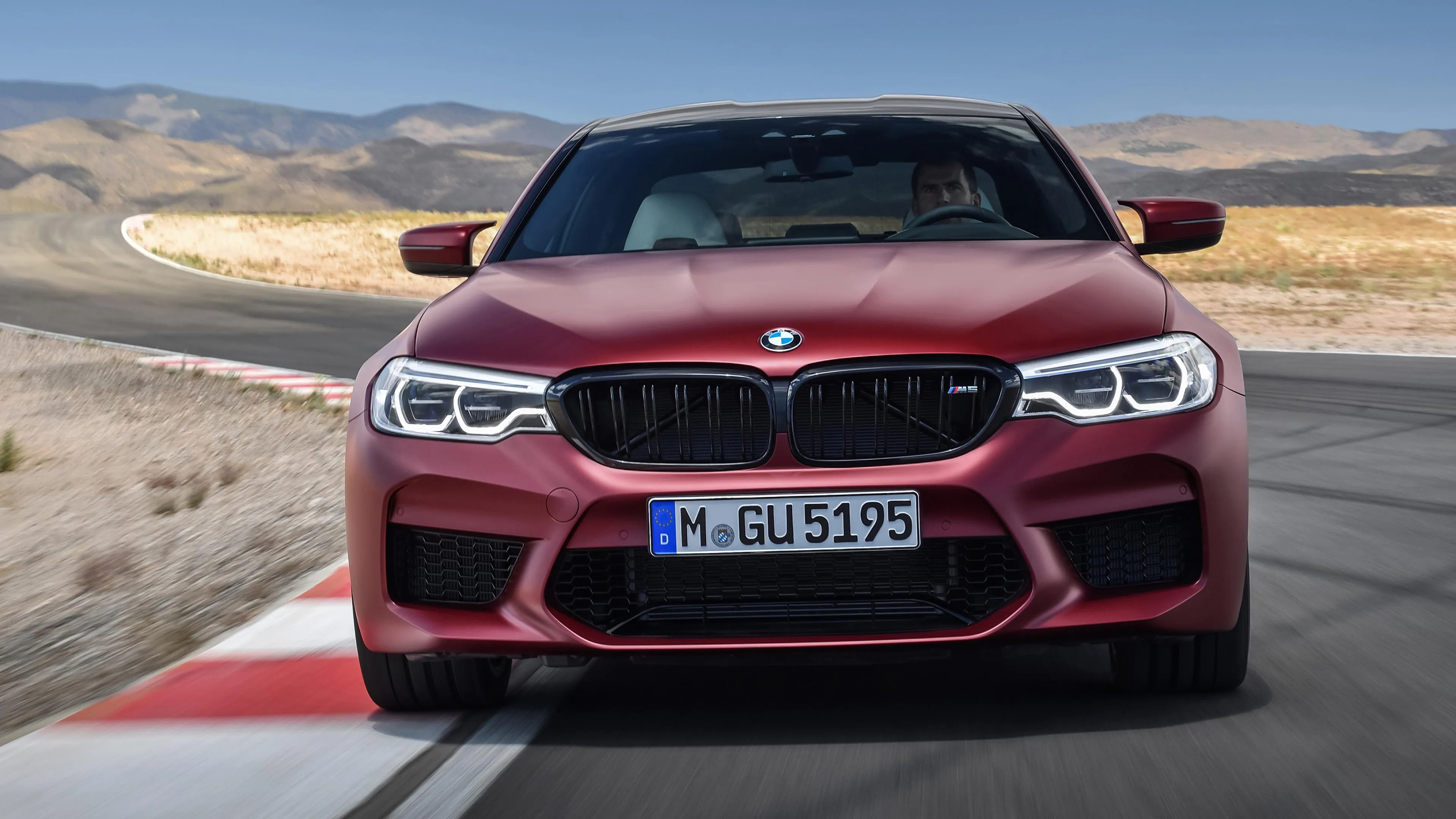 Red Bmw Parked on Race Track with Desert Hills Image
