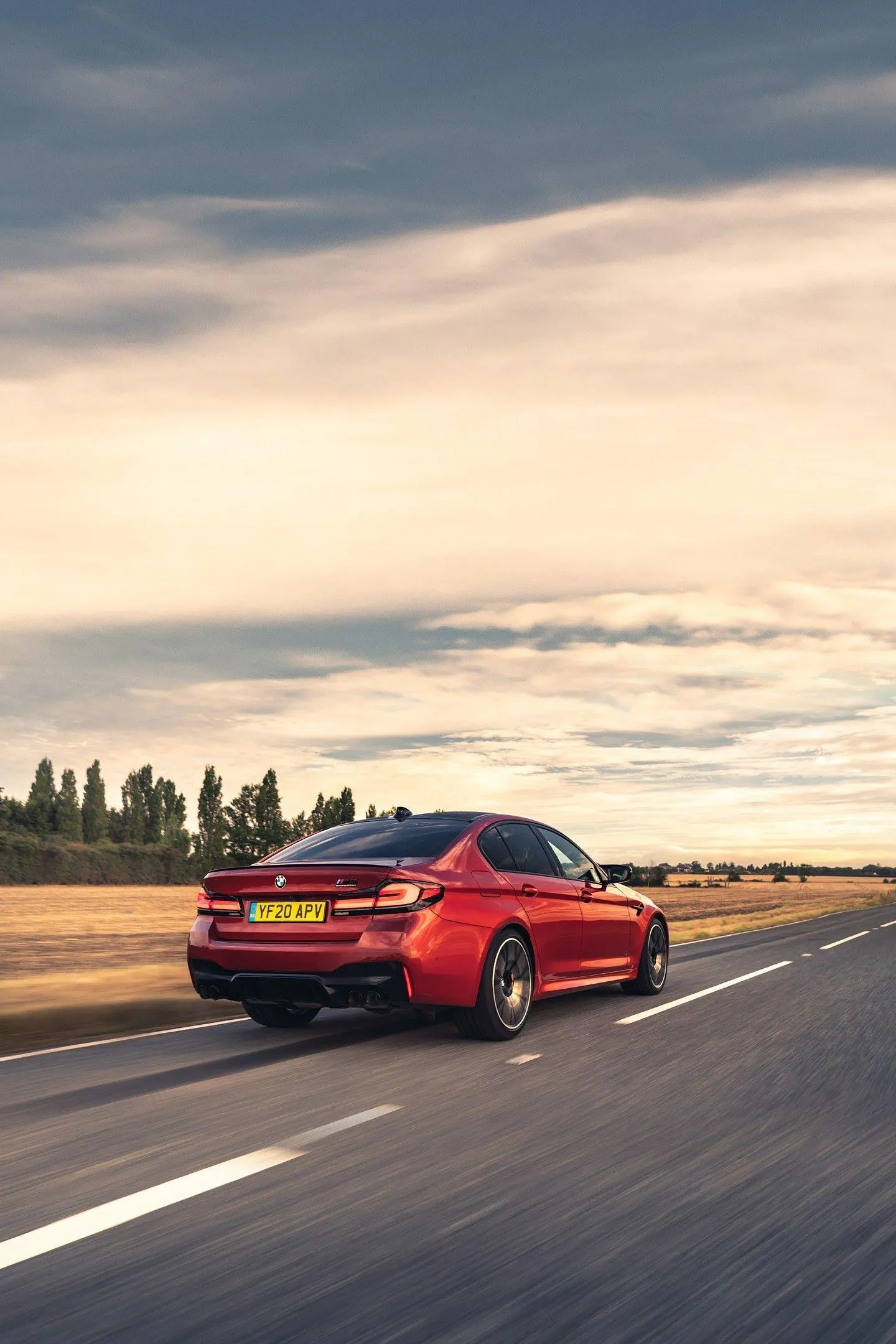 Red Bmw Sedan Driving Fast on Open Highway at Dusk