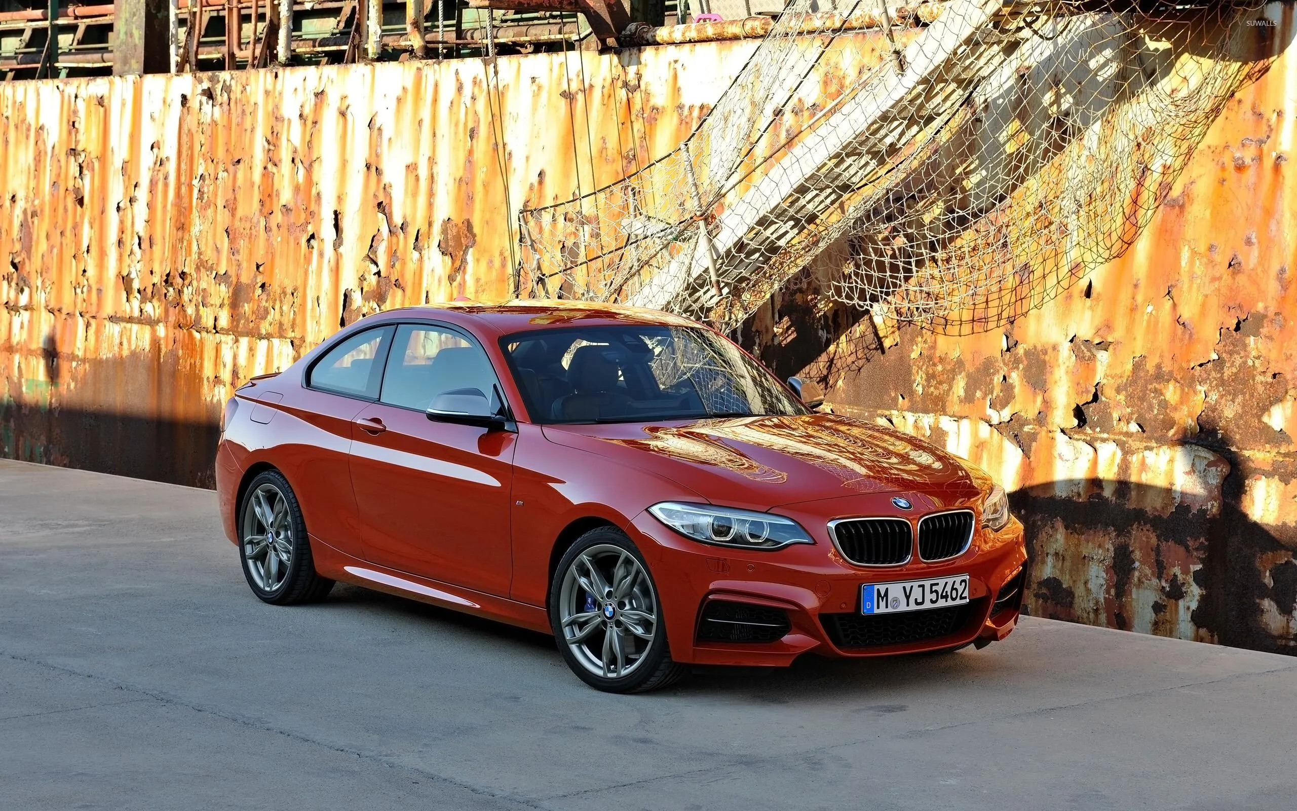 Red Bmw Sedan on Industrial Bridge with Steel Beams