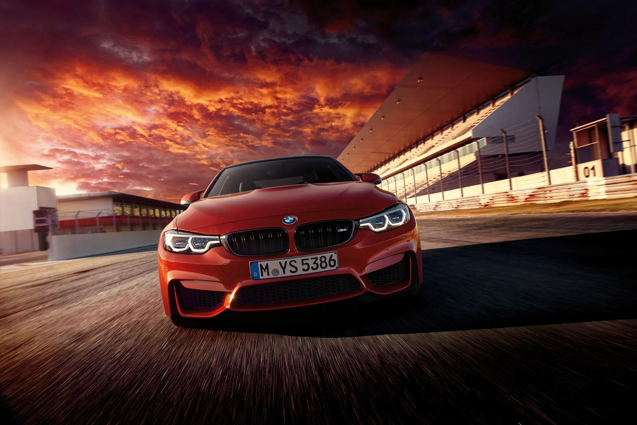 Red Bmw Sports Car on Racetrack at Dramatic Sunset