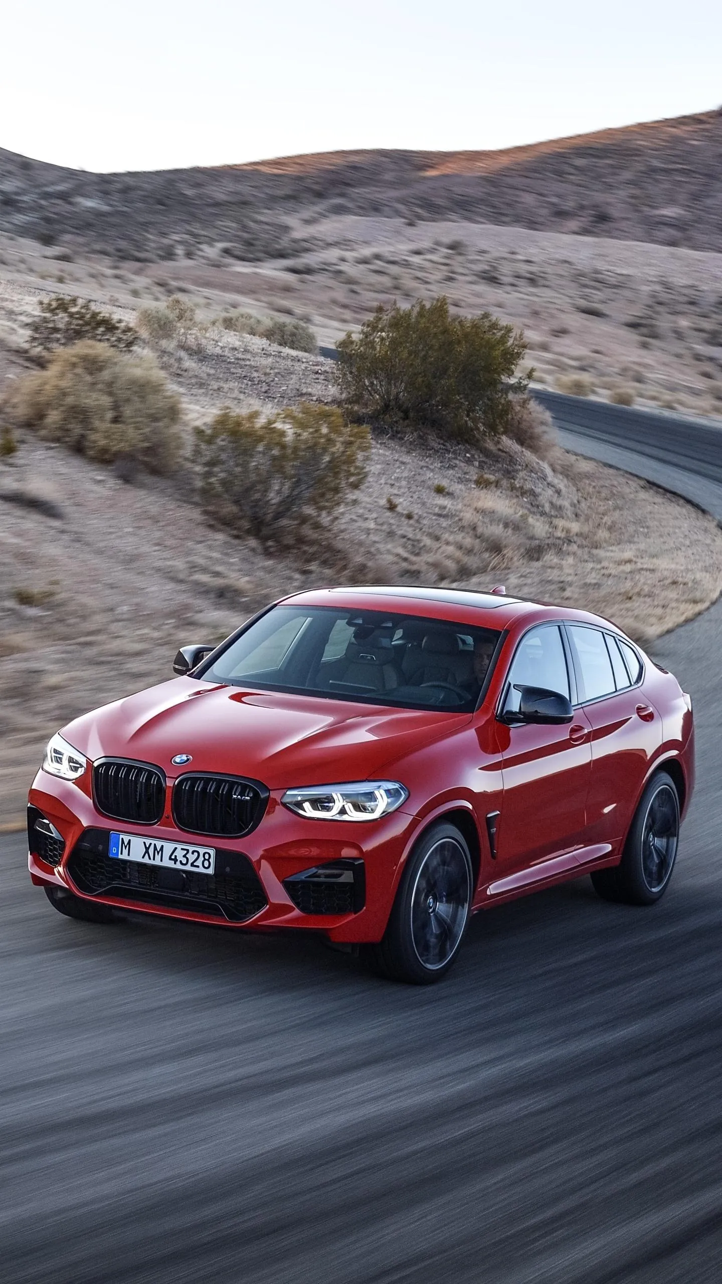Red Bmw Suv Driving Fast on Desert Mountain Road Wallpaper
