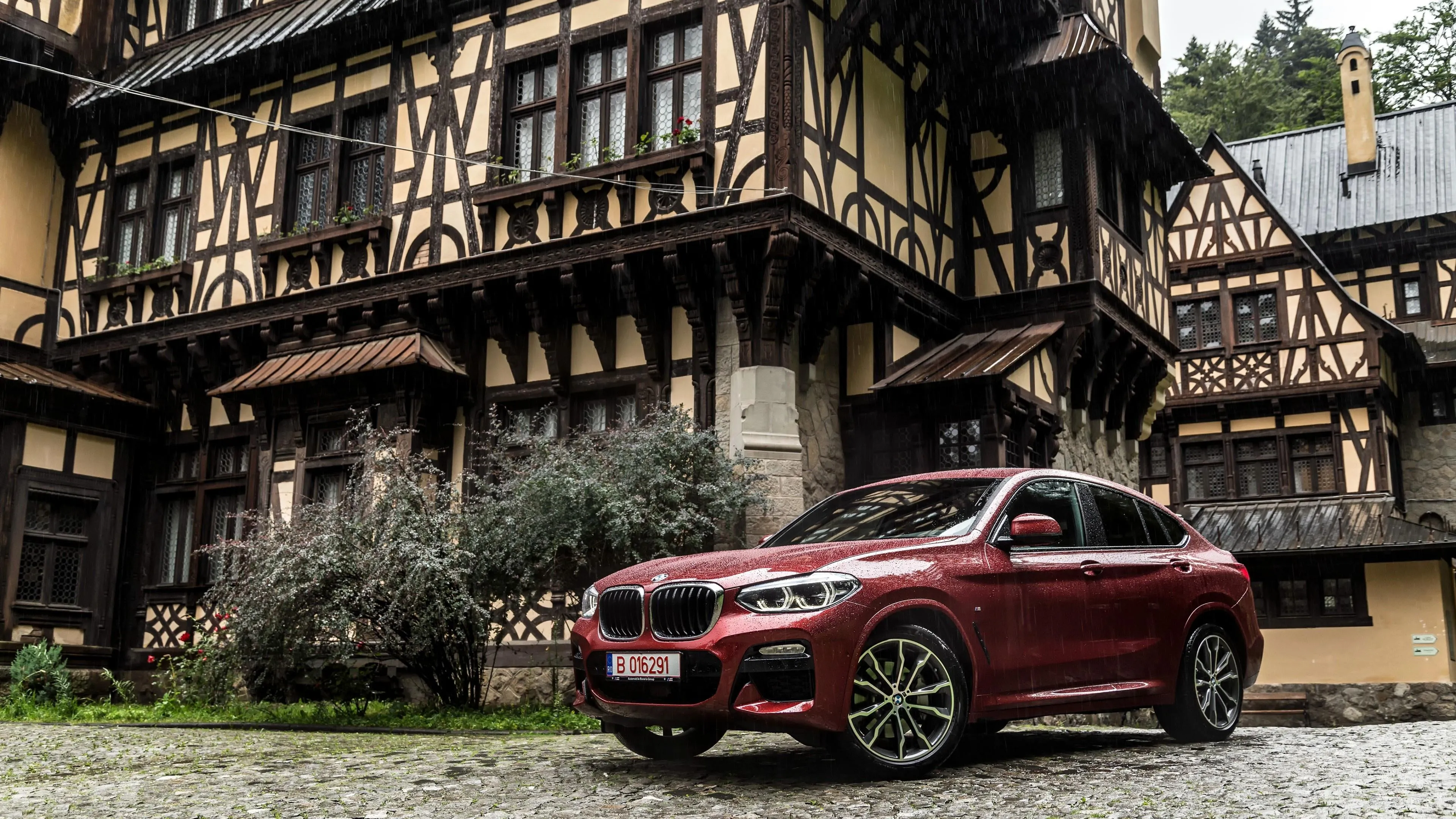 Red Bmw Suv Parked in Front of Timber Framed Vintage House
