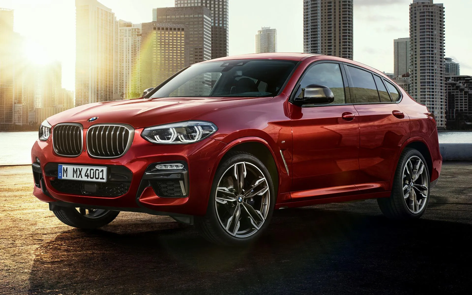 Red Bmw Suv Parked in Urban Setting at Sunset Wallpaper