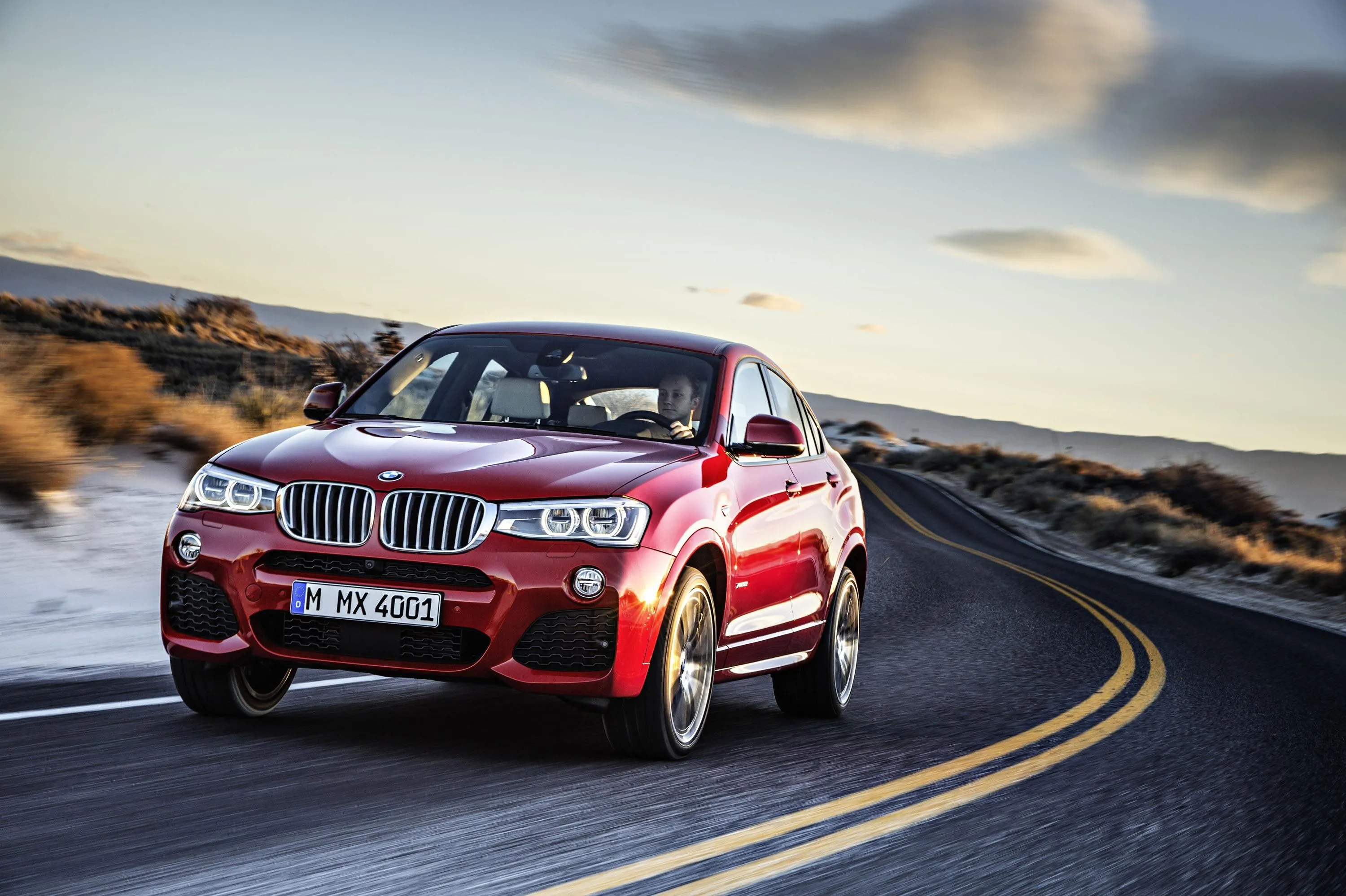 Red Bmw Turning on Winding Mountain Road with Clear Sky